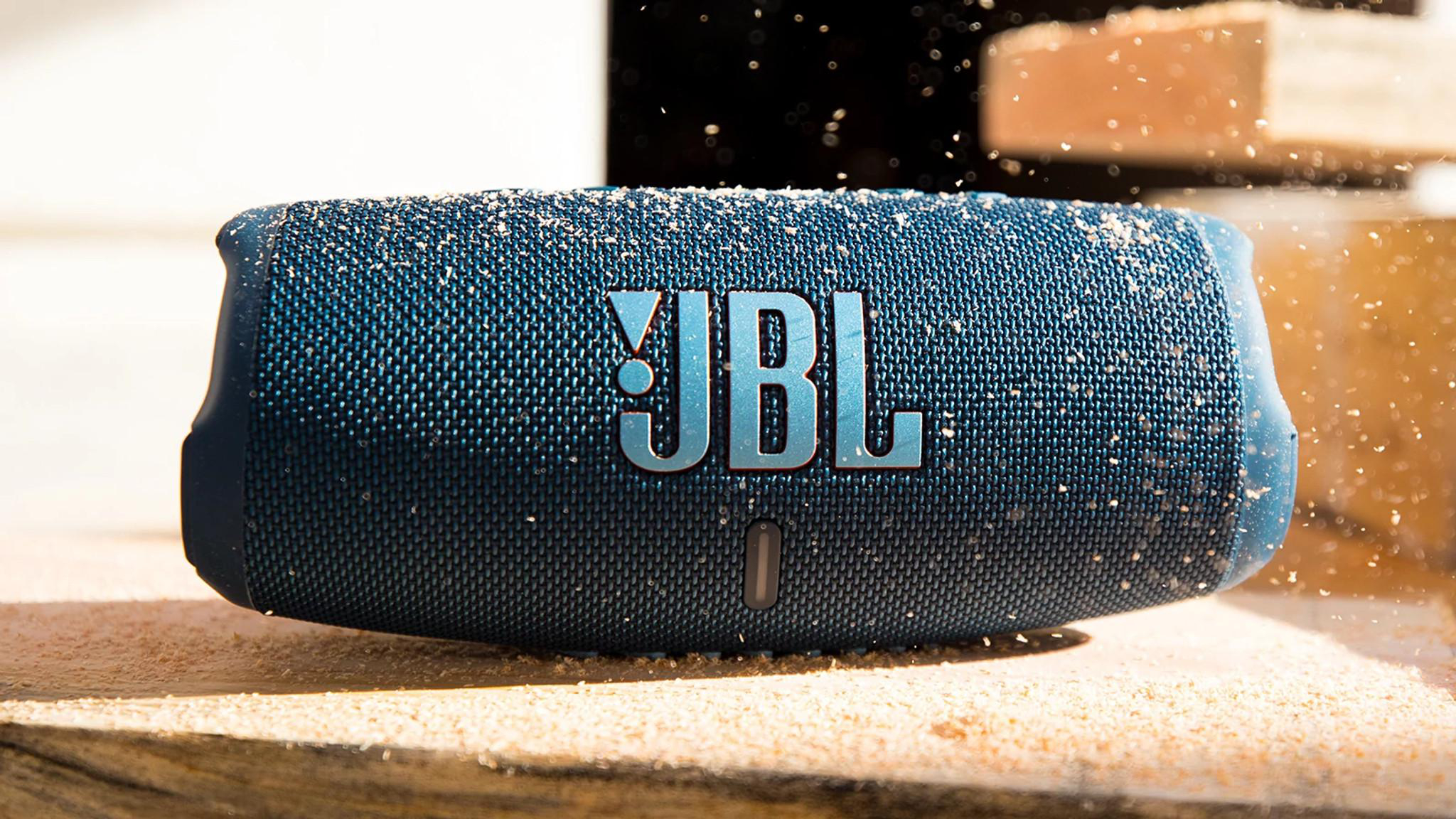 JBL Bluetooth-Lautsprecher auf Holzoberfläche mit Sägemehl.