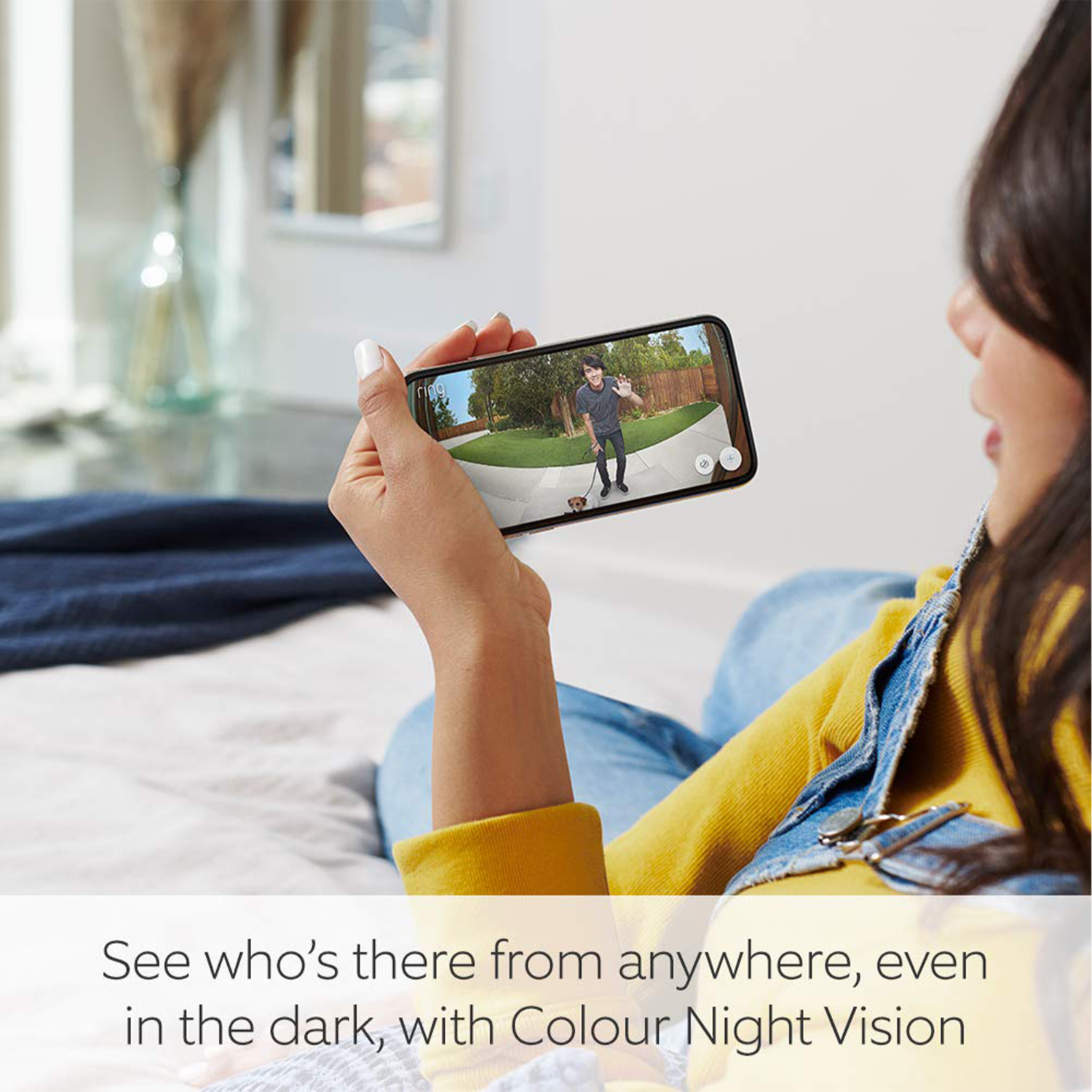 Vrouw houdt telefoon vast met live videofeed, persoon op de achtergrond.