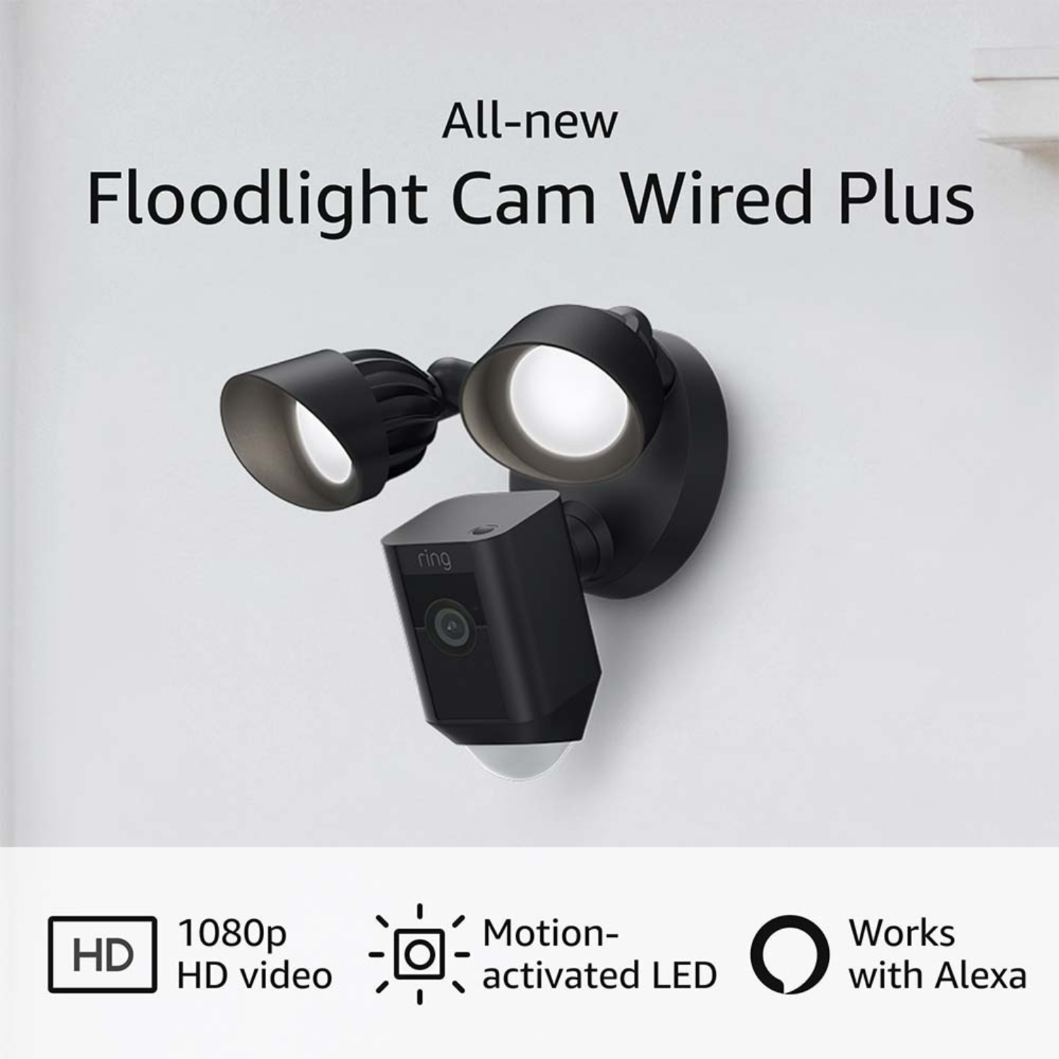 Zwarte schijnwerpercamera met twee lampen en een camera. Tekst: All-new Floodlight Cam Wired Plus.