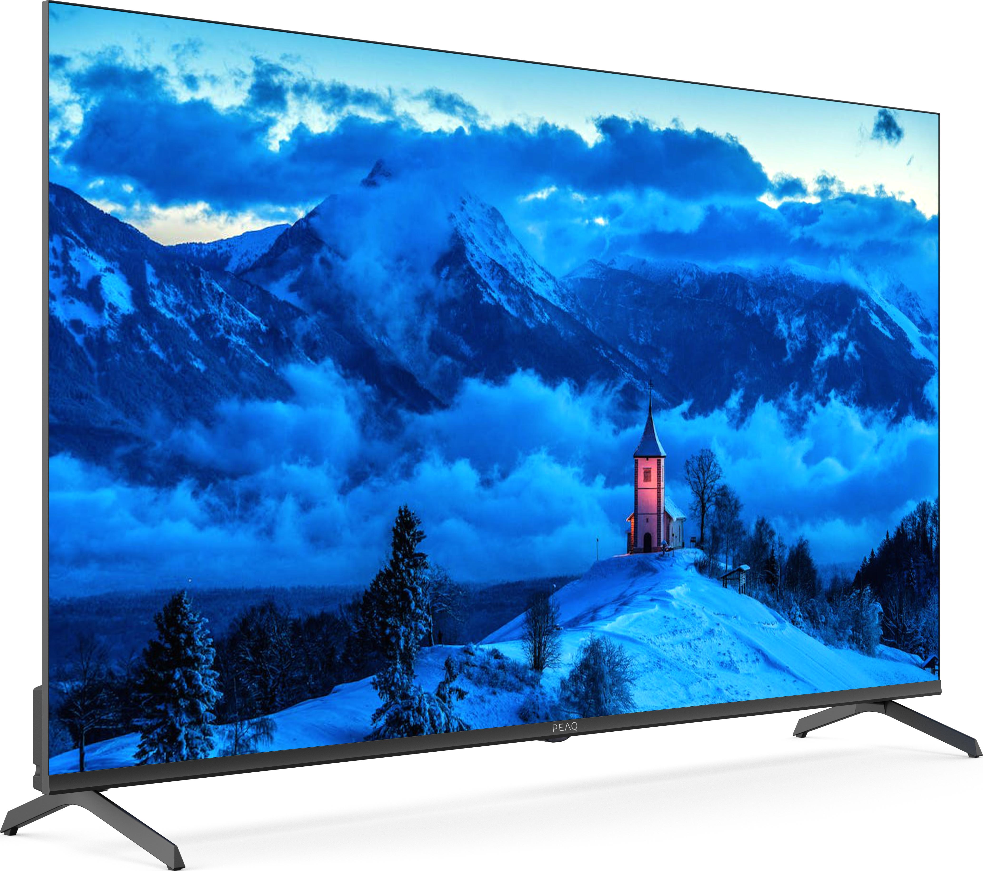 Una grande TV che mostra un paesaggio montano innevato.
