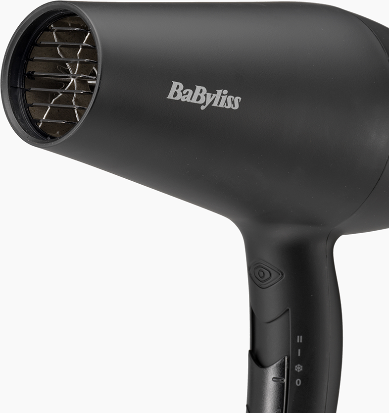 Fekete hajszárító 'BaByliss' logóval, vezérlőkkel és fémráccsal ellátott levegő kimenettel.