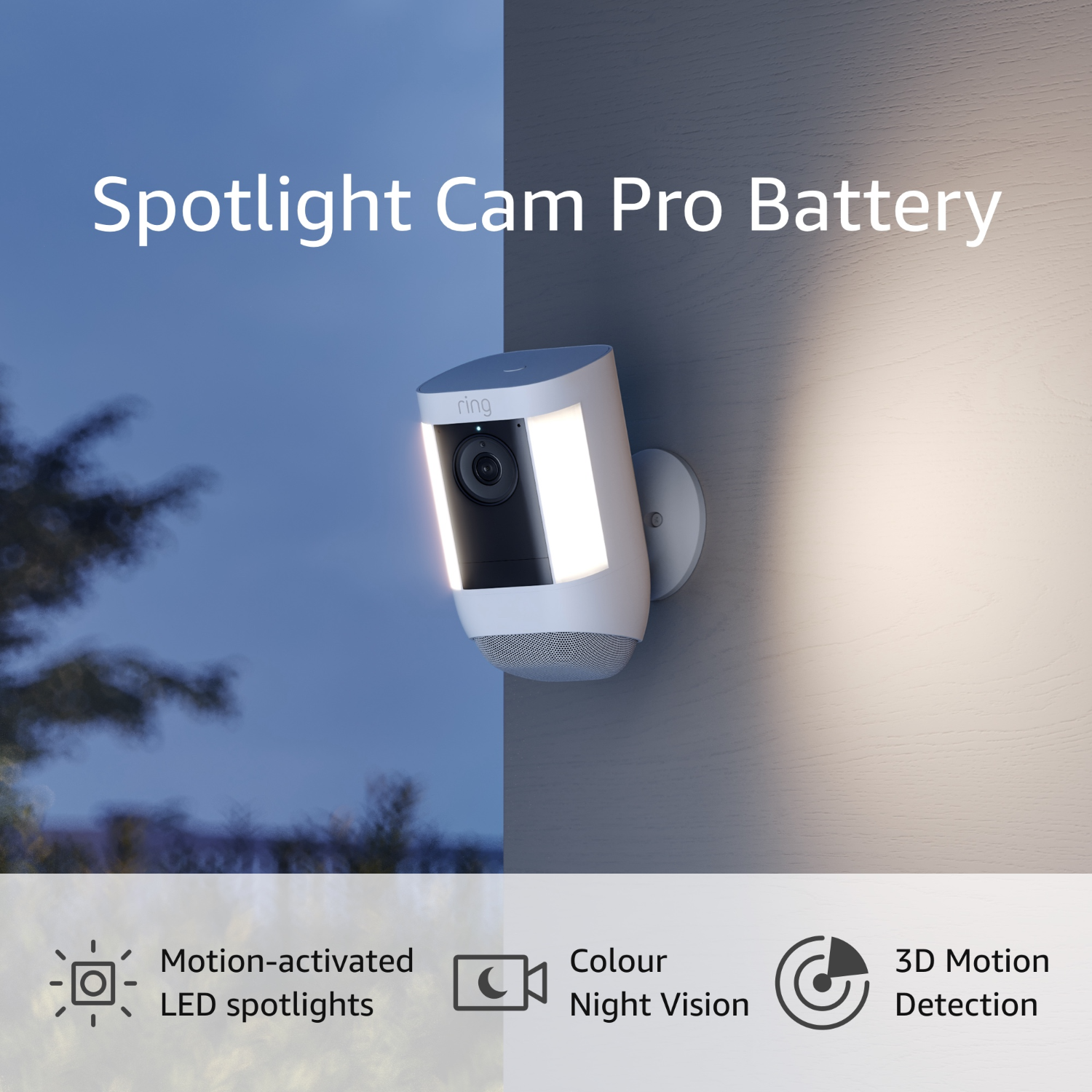 A white Ring Spotlight Cam Pro Battery security camera mounted on a wall, with a dark sky.