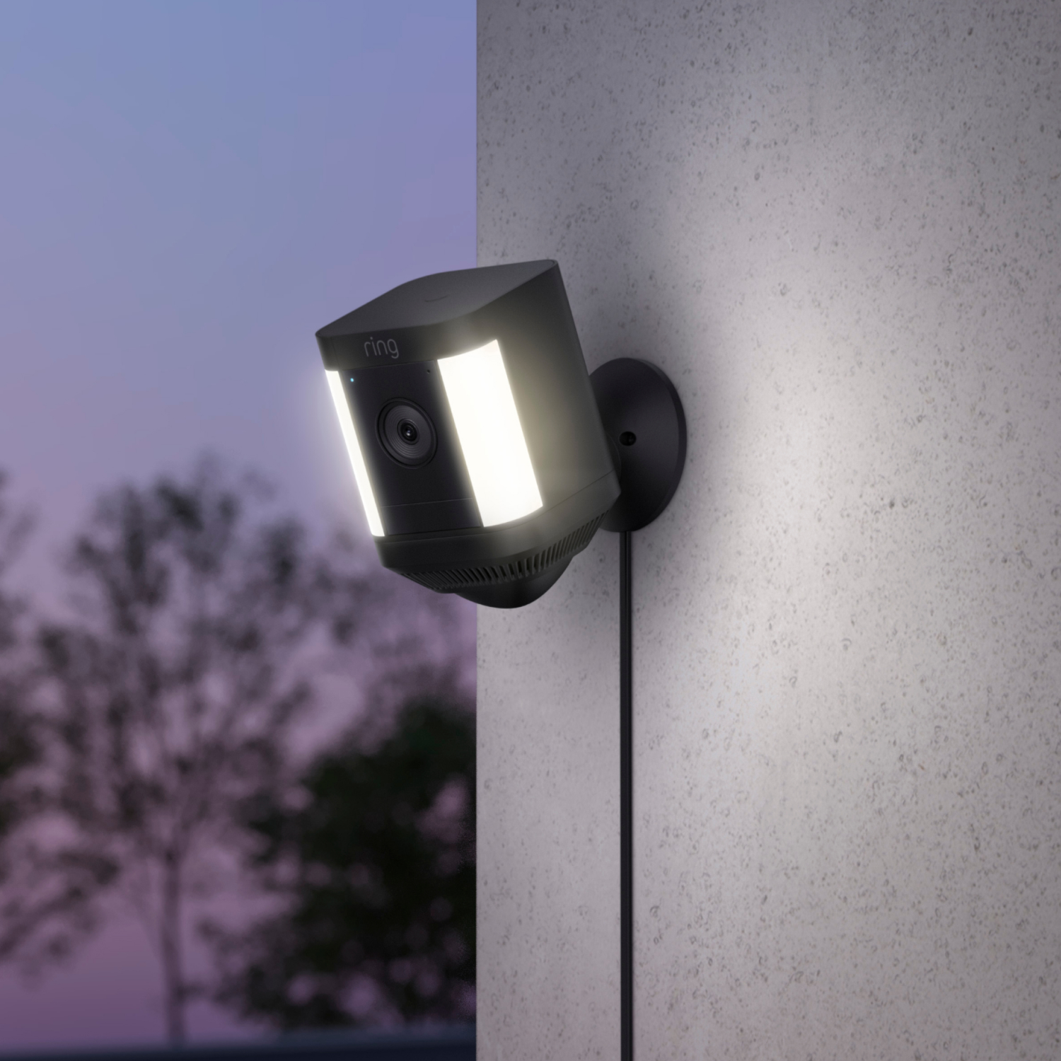 Zwarte Ring-beveiligingscamera op grijze muur, verlicht. Toont camera en twee lichten.
