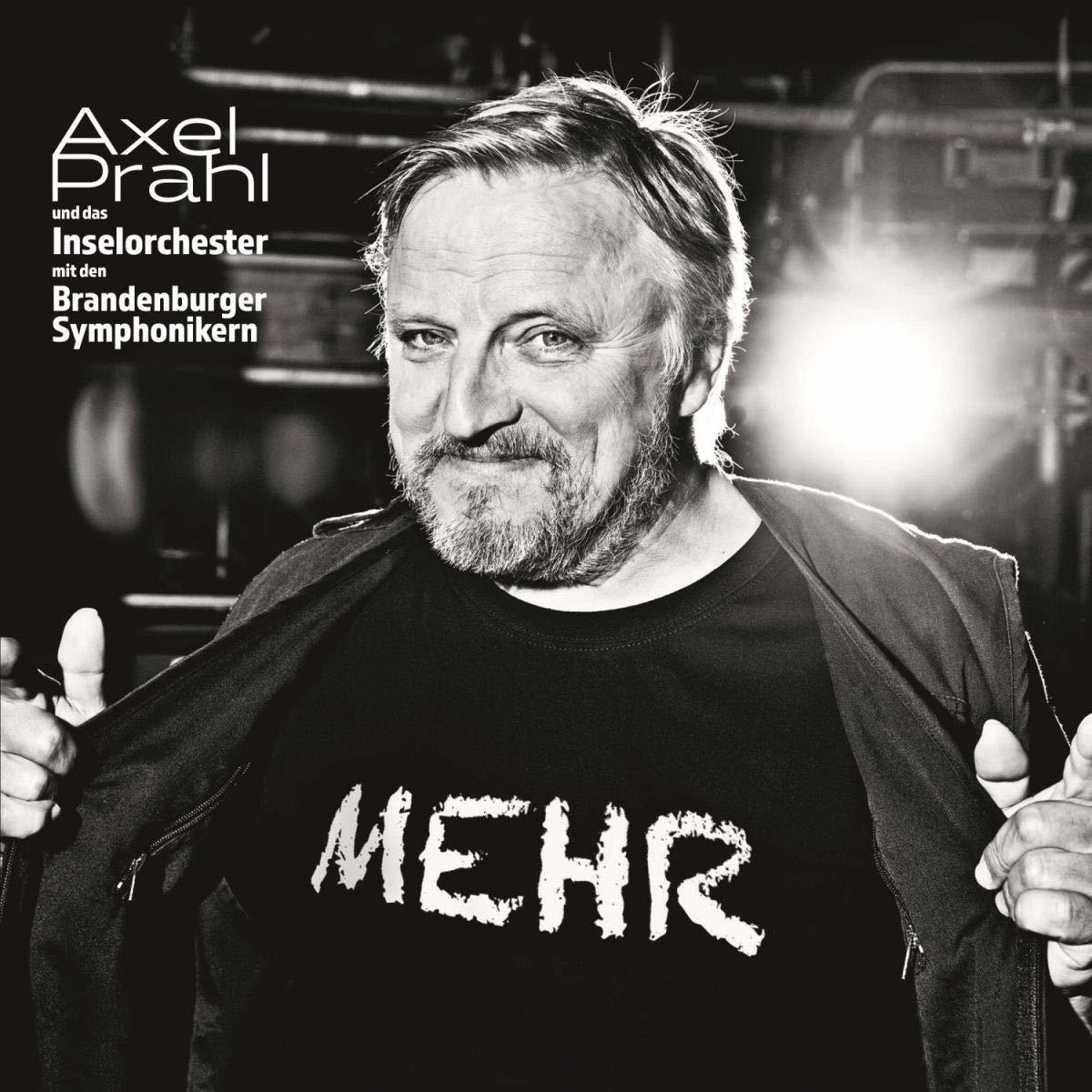 Axel Prahl Albumcover. Axel trägt ein schwarzes T-Shirt mit "MEHR". Lächelnd.