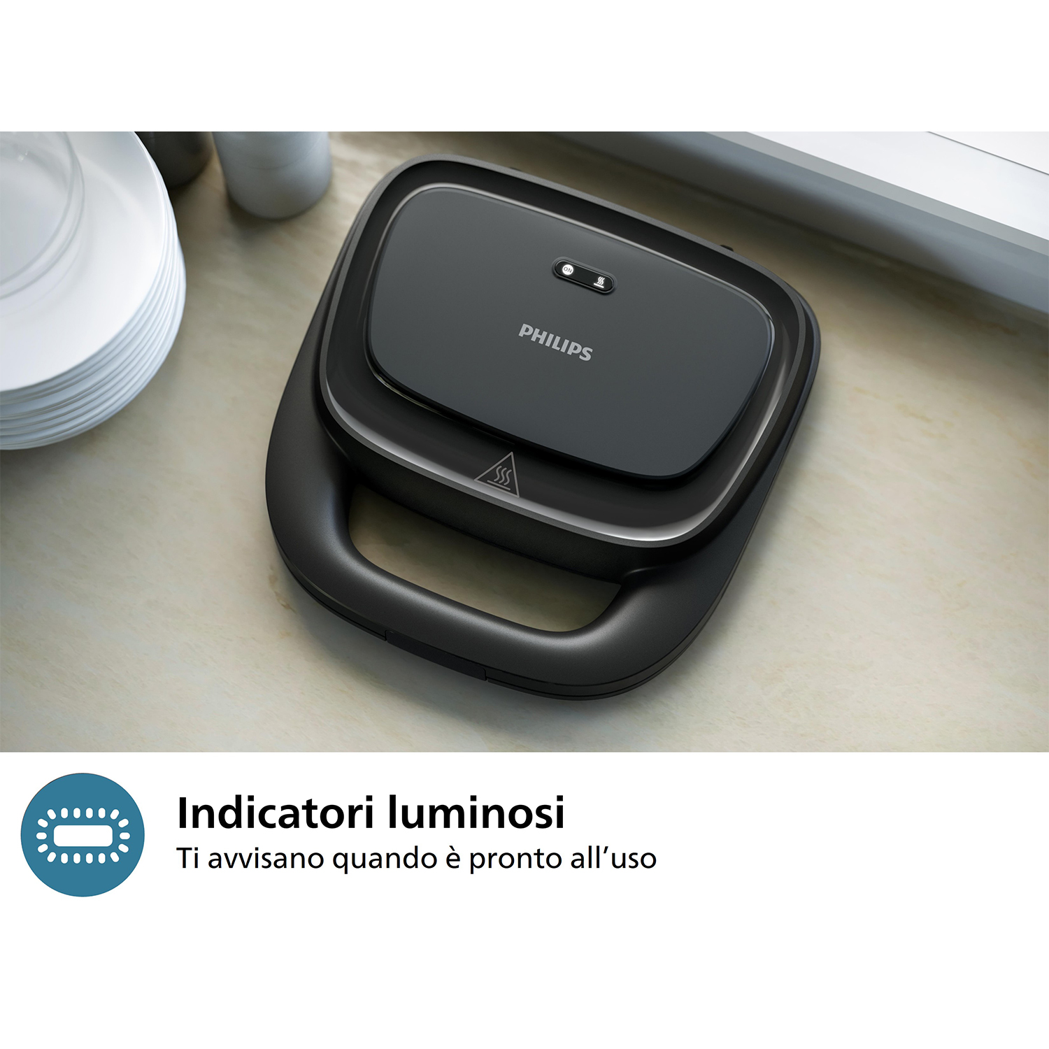 Sandwich maker nero su un piano di lavoro beige con una parete bianca sullo sfondo. Mostra spie luminose.