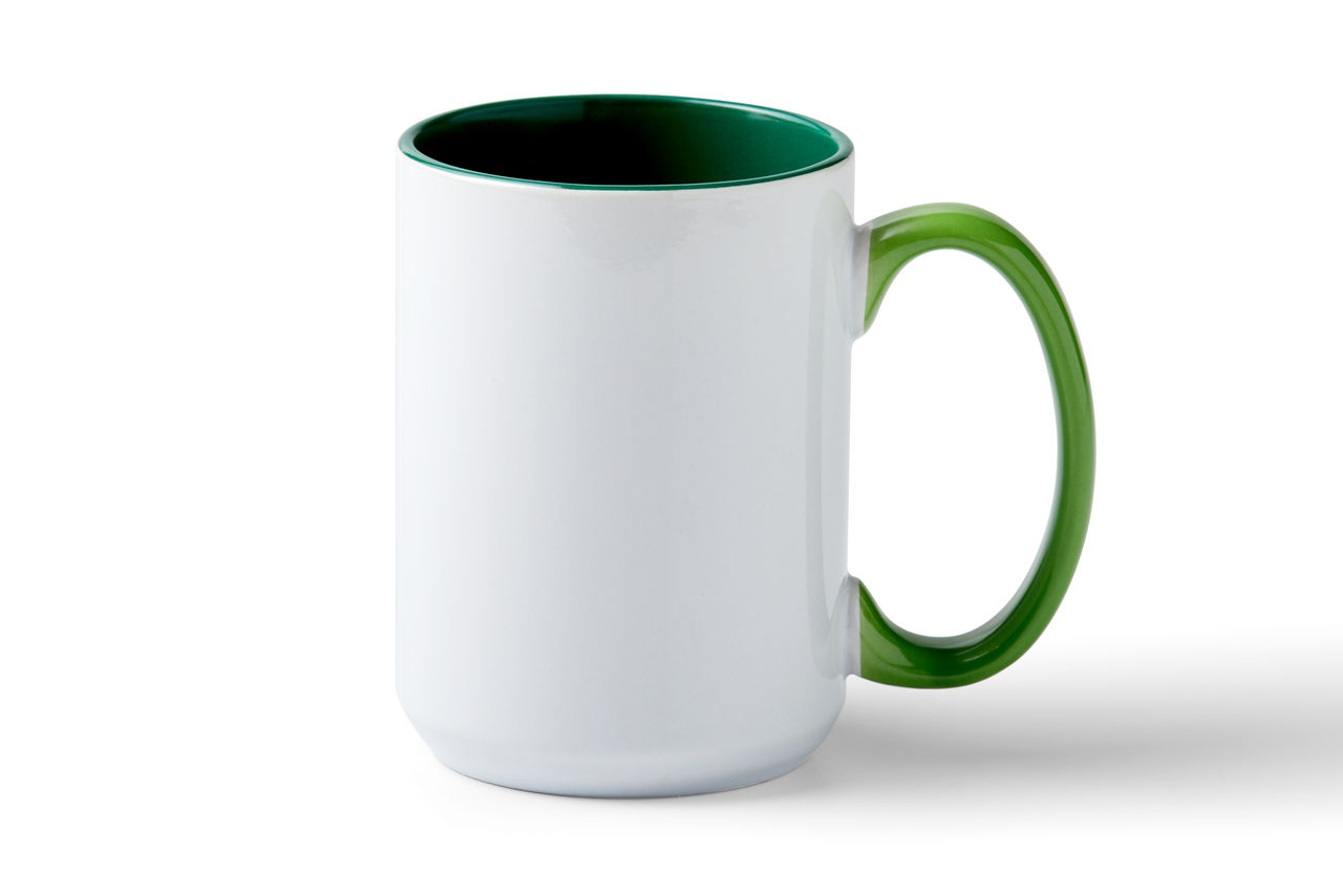 Weißer Becher mit grünem Griff und Innenraum. Er wirft einen Schatten auf eine weiße Oberfläche.