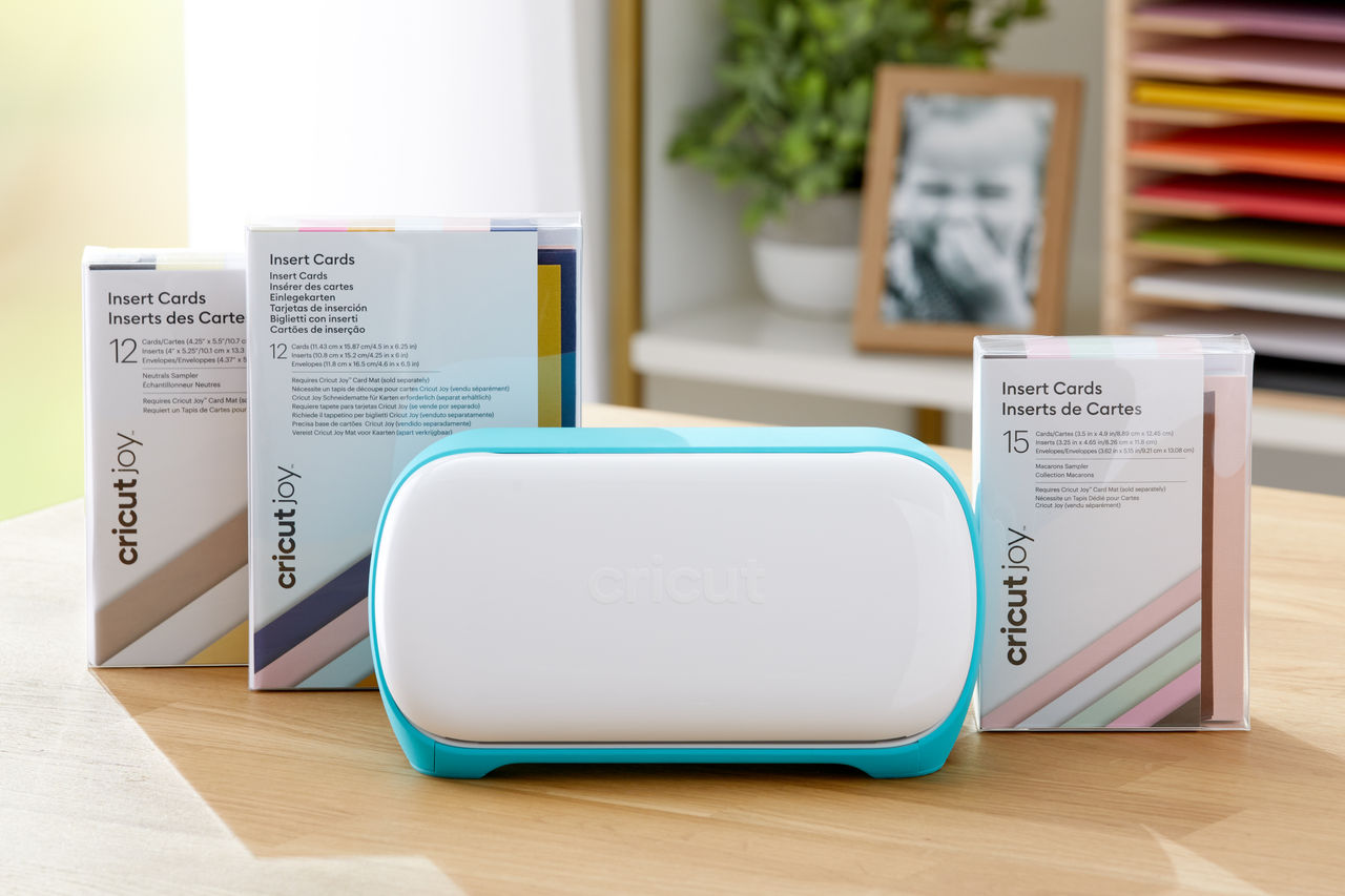 Cricut Joy Maschine mit Karteneinsatz-Schachteln und einem gerahmten Foto.