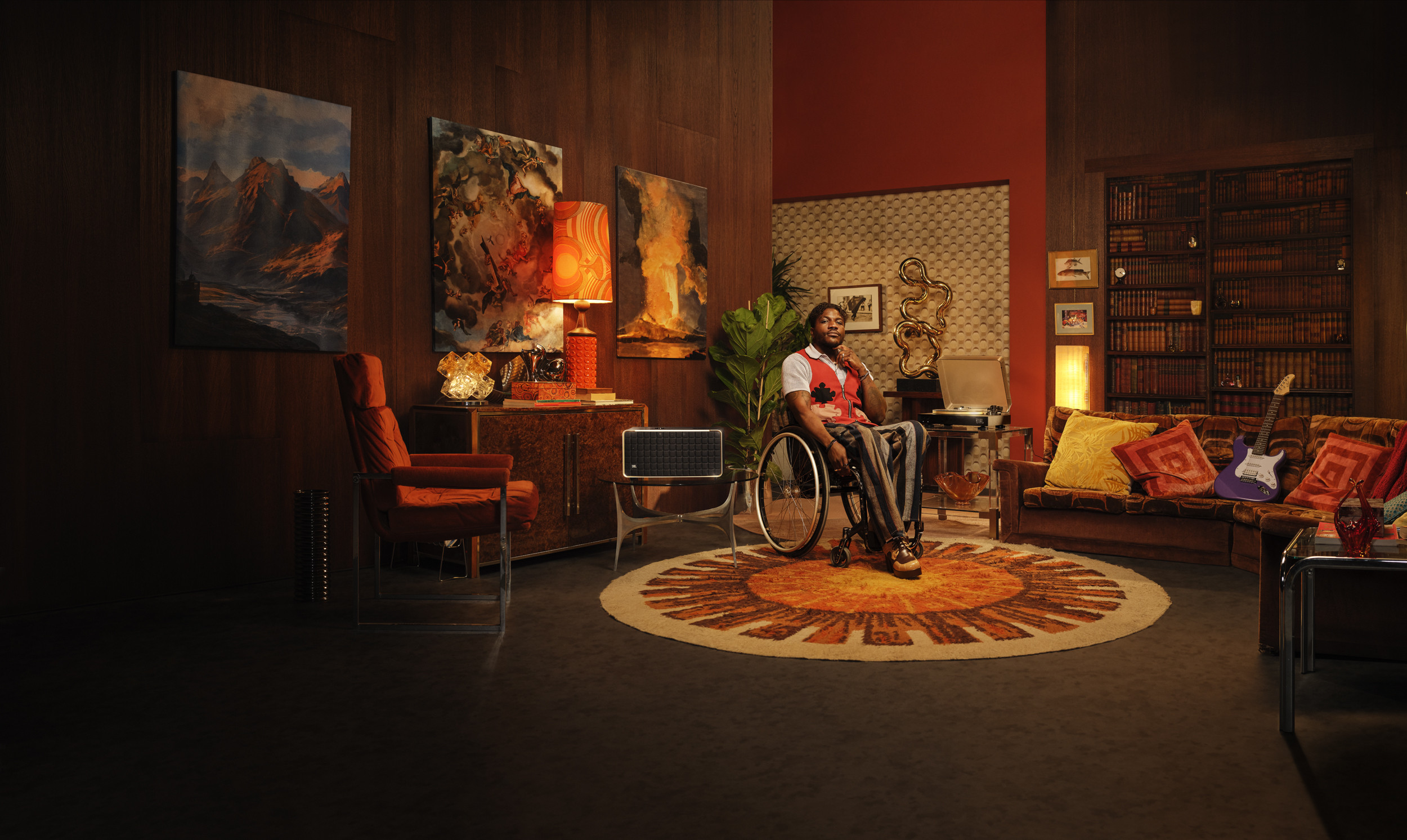 Un homme en fauteuil roulant est assis dans un salon rétro avec de l'art et une guitare.