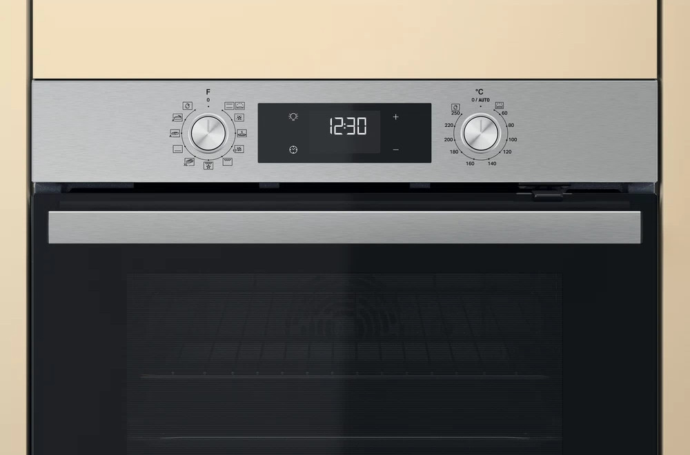 A close-up of an oven control panel, showing dials and a digital display.