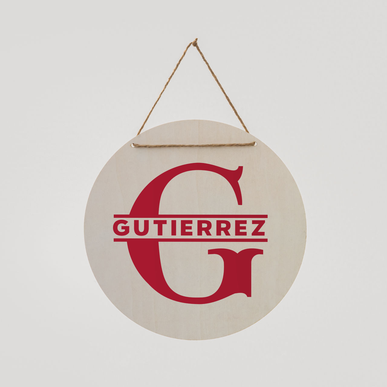 Ein rundes Holzschild mit einem roten 'G' und dem Namen 'Gutierrez'. Es hängt an einem Seil.