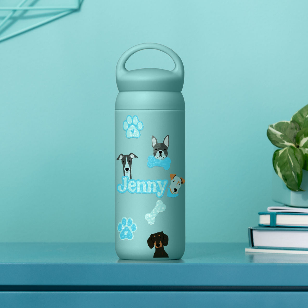 Hellblaue Wasserflasche mit Hundeaufklebern und dem Namen Jenny. Hellblaue Oberfläche.