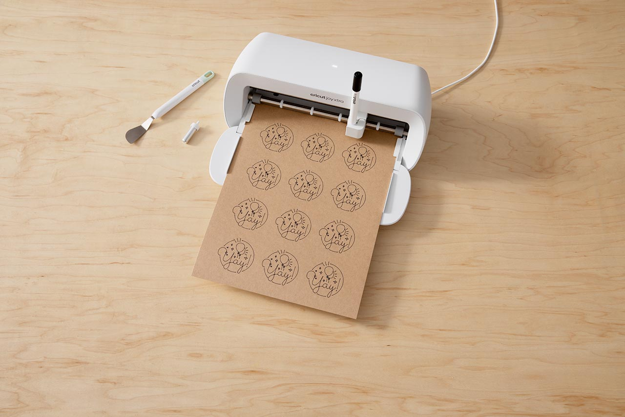 Eine Bastelmaschine, die Aufkleber ausgibt. Mehrere Aufkleber werden auf Papier gedruckt.