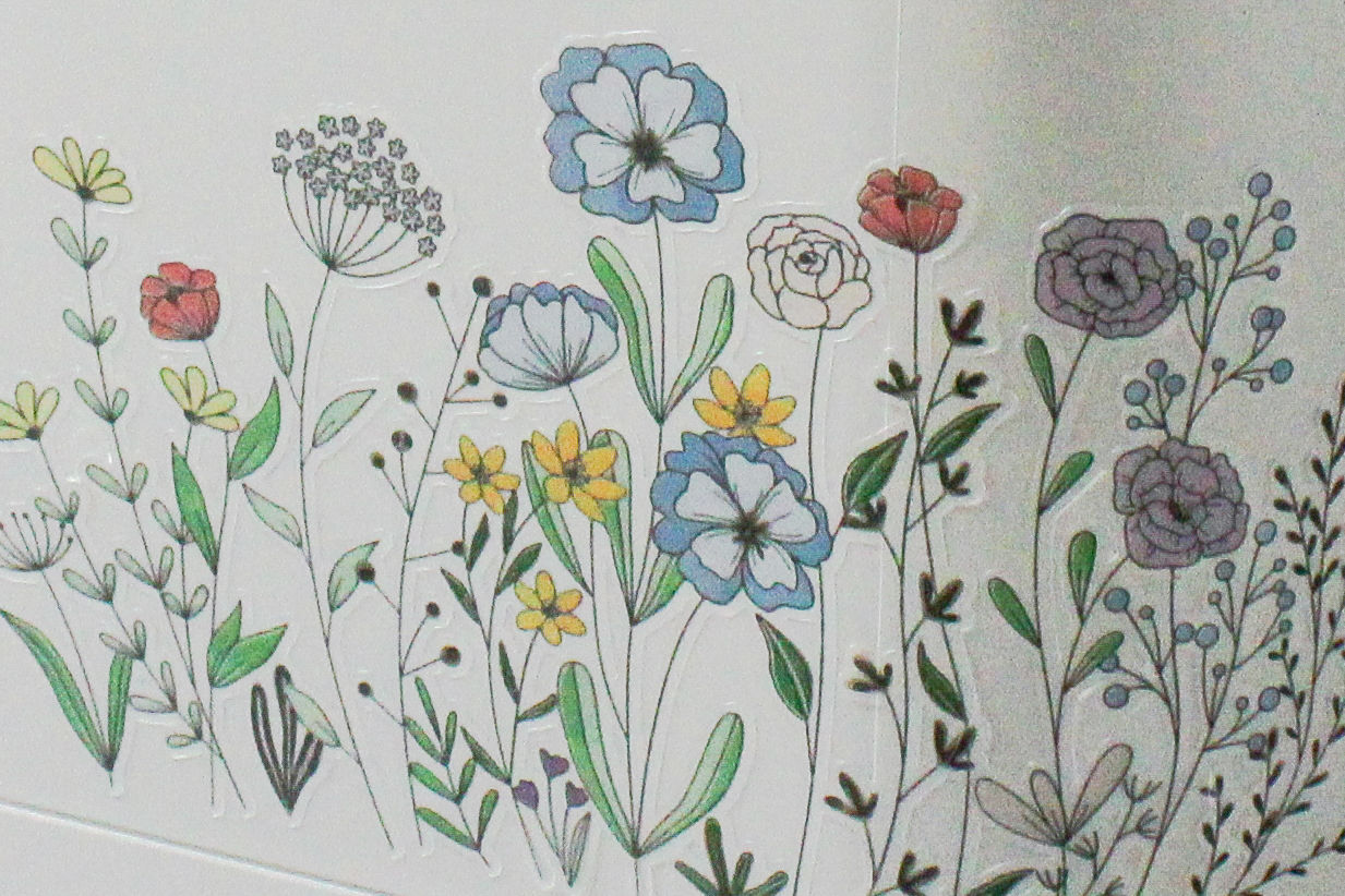 Nahaufnahme von bunten Blumenaufklebern auf weißer Oberfläche.