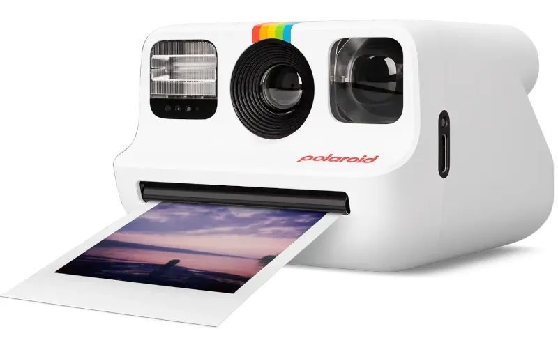 Biały aparat Polaroid z kolorowym paskiem, drukujący zdjęcie.