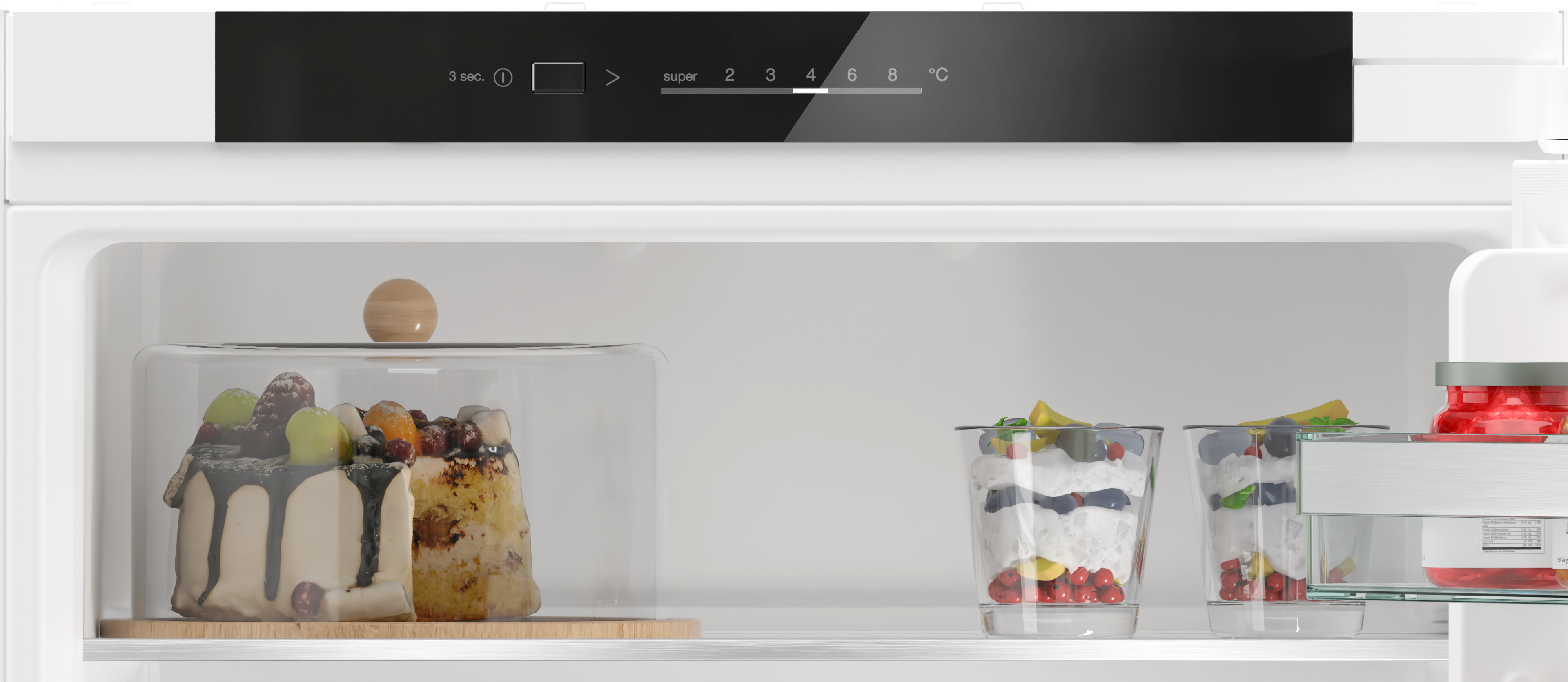 Ein Kühlschrank mit Desserts. Kuchen und Parfaits sind sichtbar, mit digitaler Steuerung oben.