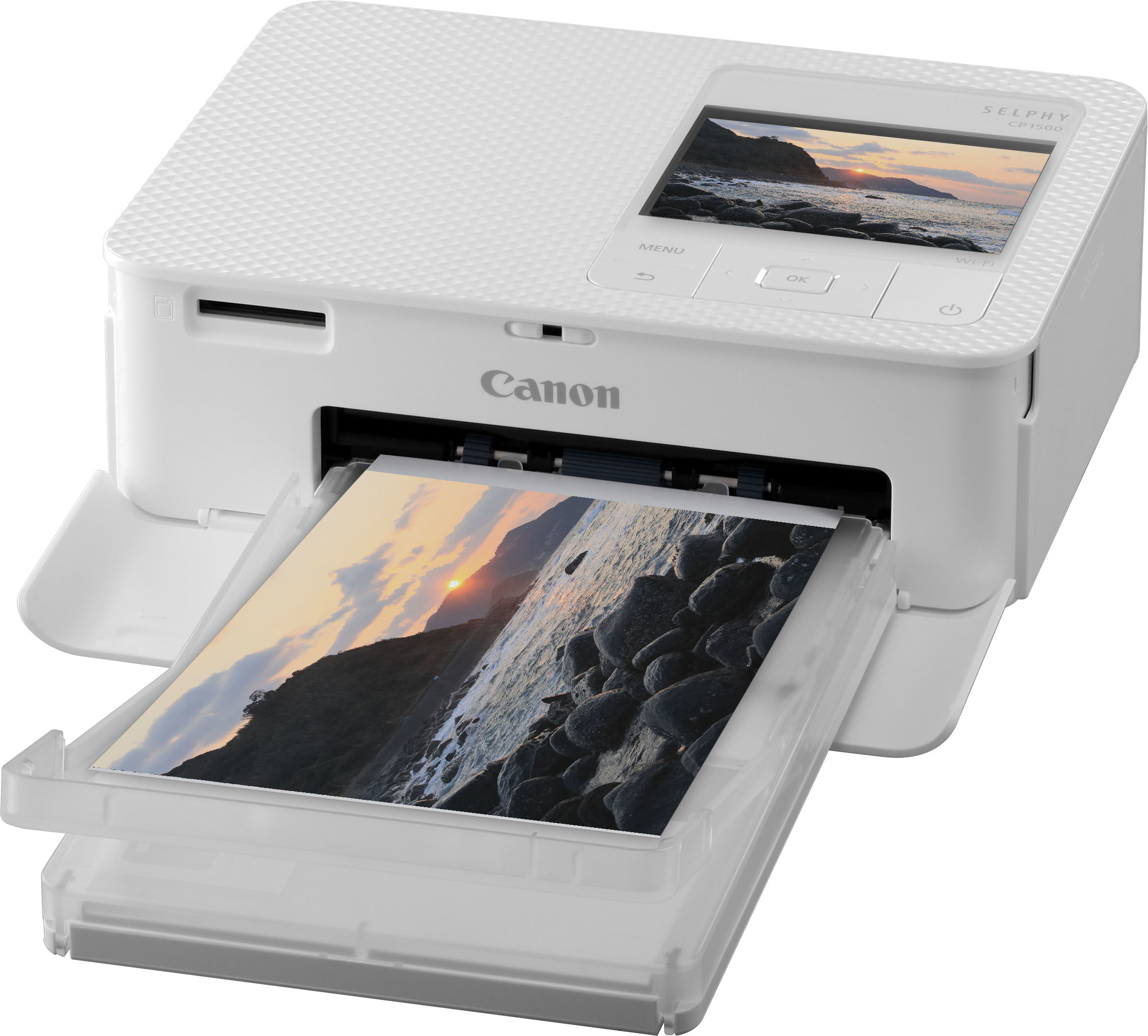 Une imprimante Canon Selphy blanche imprimant une photo d'un coucher de soleil sur une côte rocheuse.