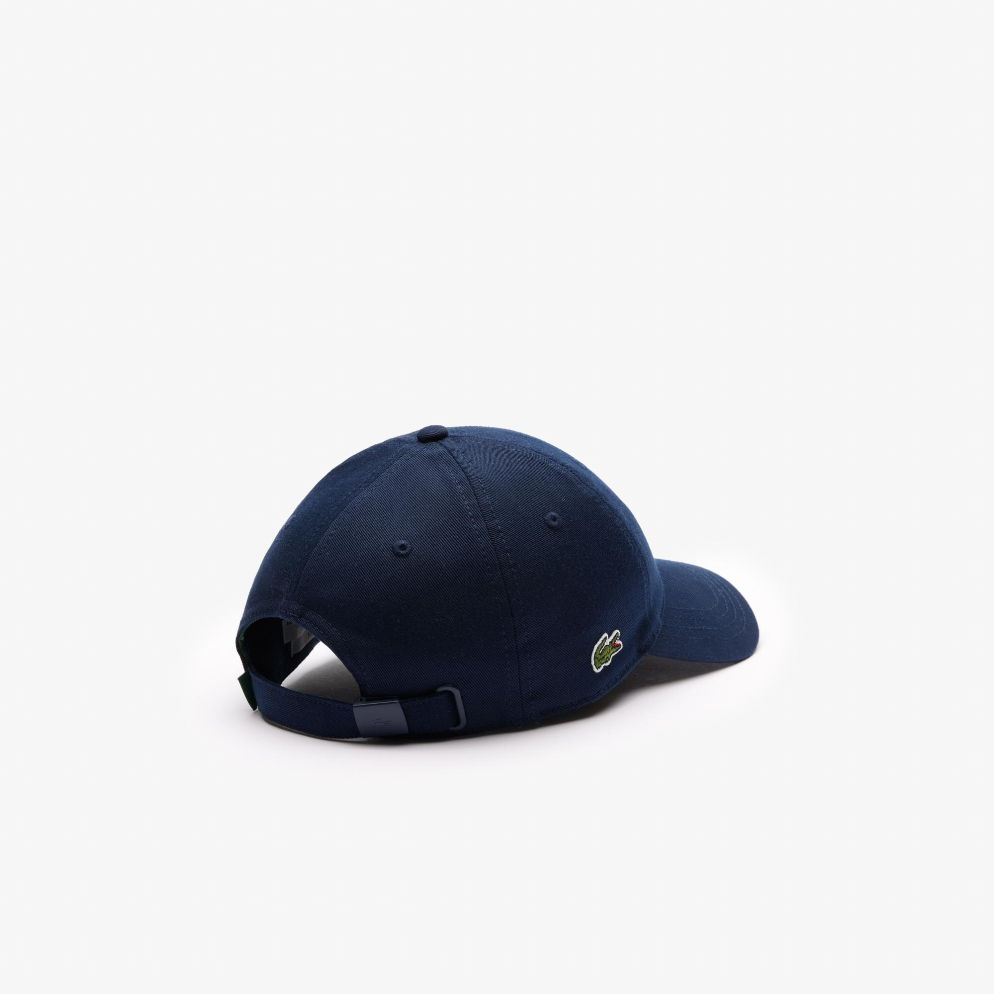 Marineblaue Lacoste-Kappe mit grünem Krokodil-Logo an der Seite, Rückansicht.