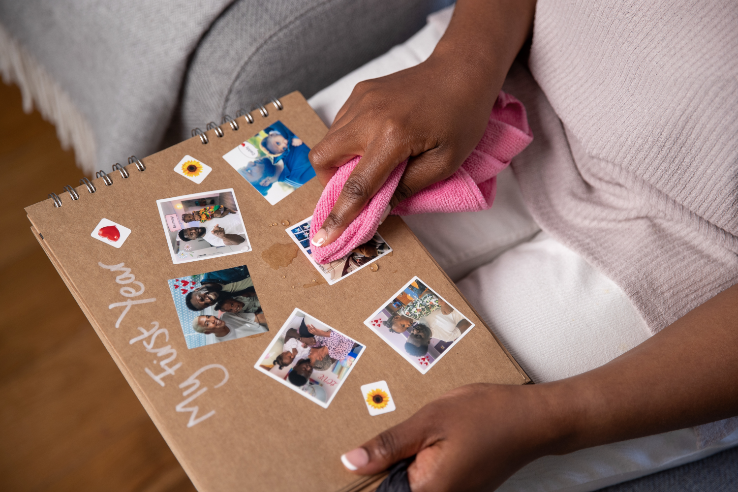 Personne nettoyant des photos dans un album. Photos et autocollants visibles.