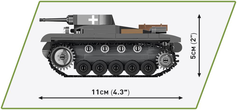 Spielzeugpanzer mit Maßangaben. Er ist grau mit weißen Markierungen und einer Kanone. Der Hintergrund ist grün.