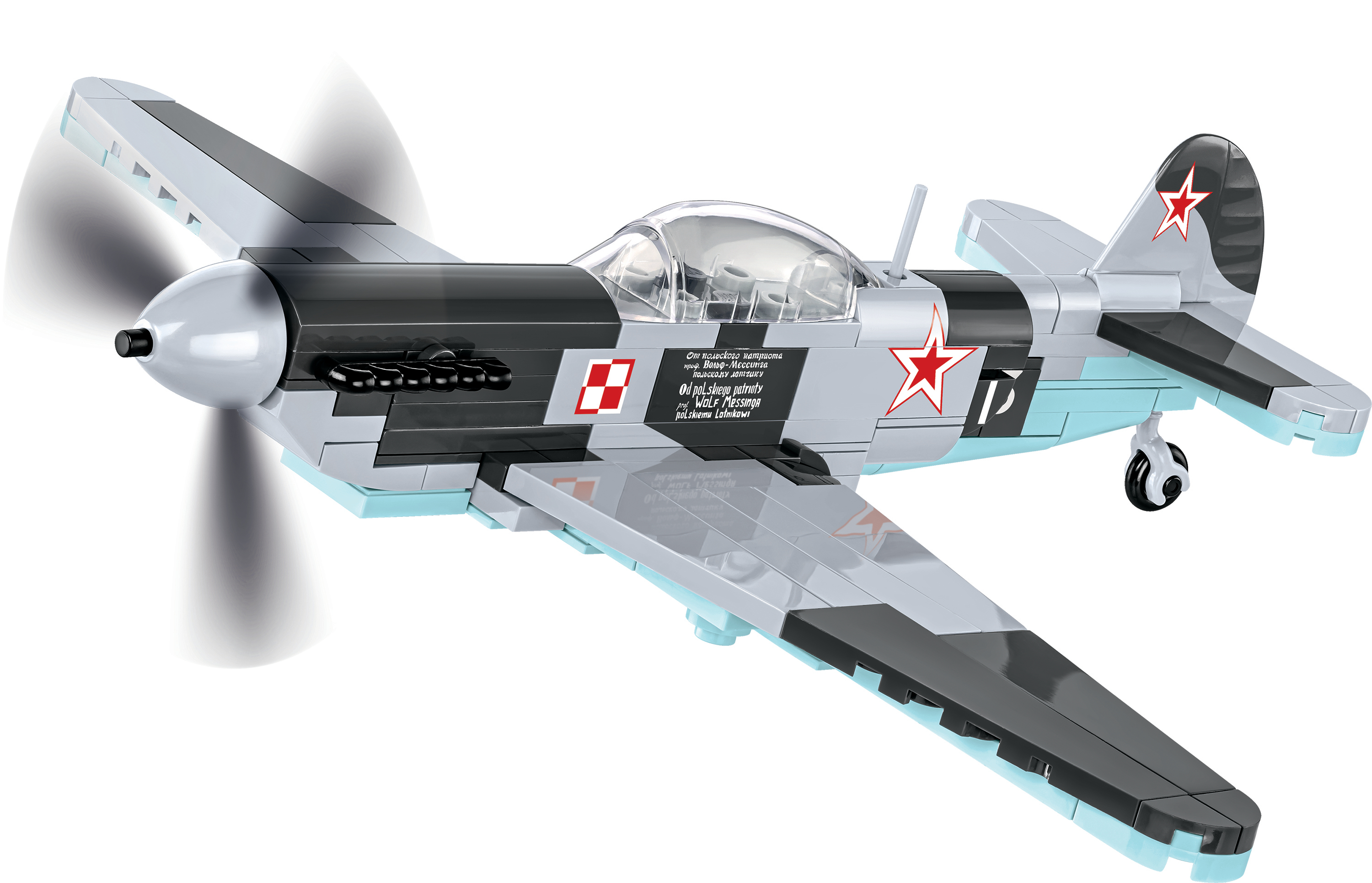 Ein grau-schwarzes Lego-Flugzeug mit einem roten Stern an der Seite. Der Propeller dreht sich.