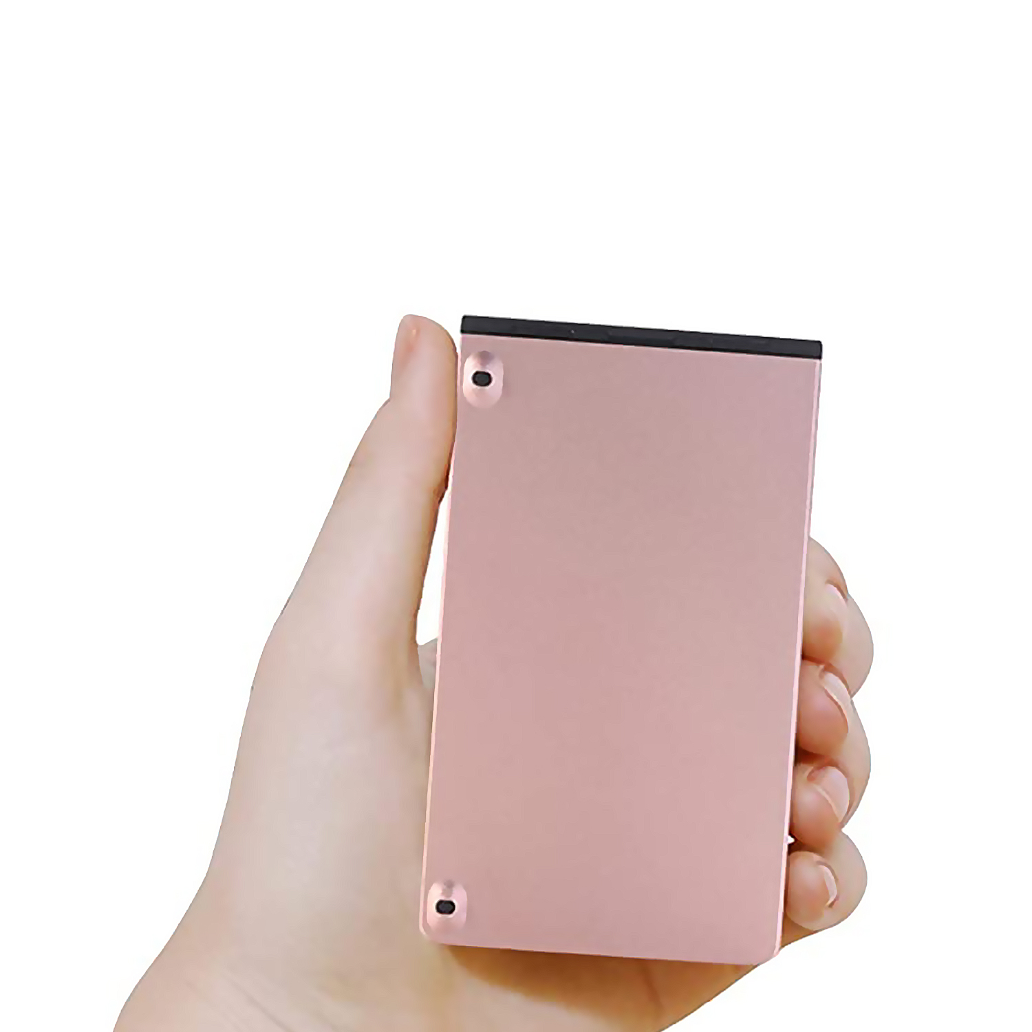 Una mano sostiene un dispositivo rectangular rosa. El dispositivo tiene dos pequeños puntos negros.