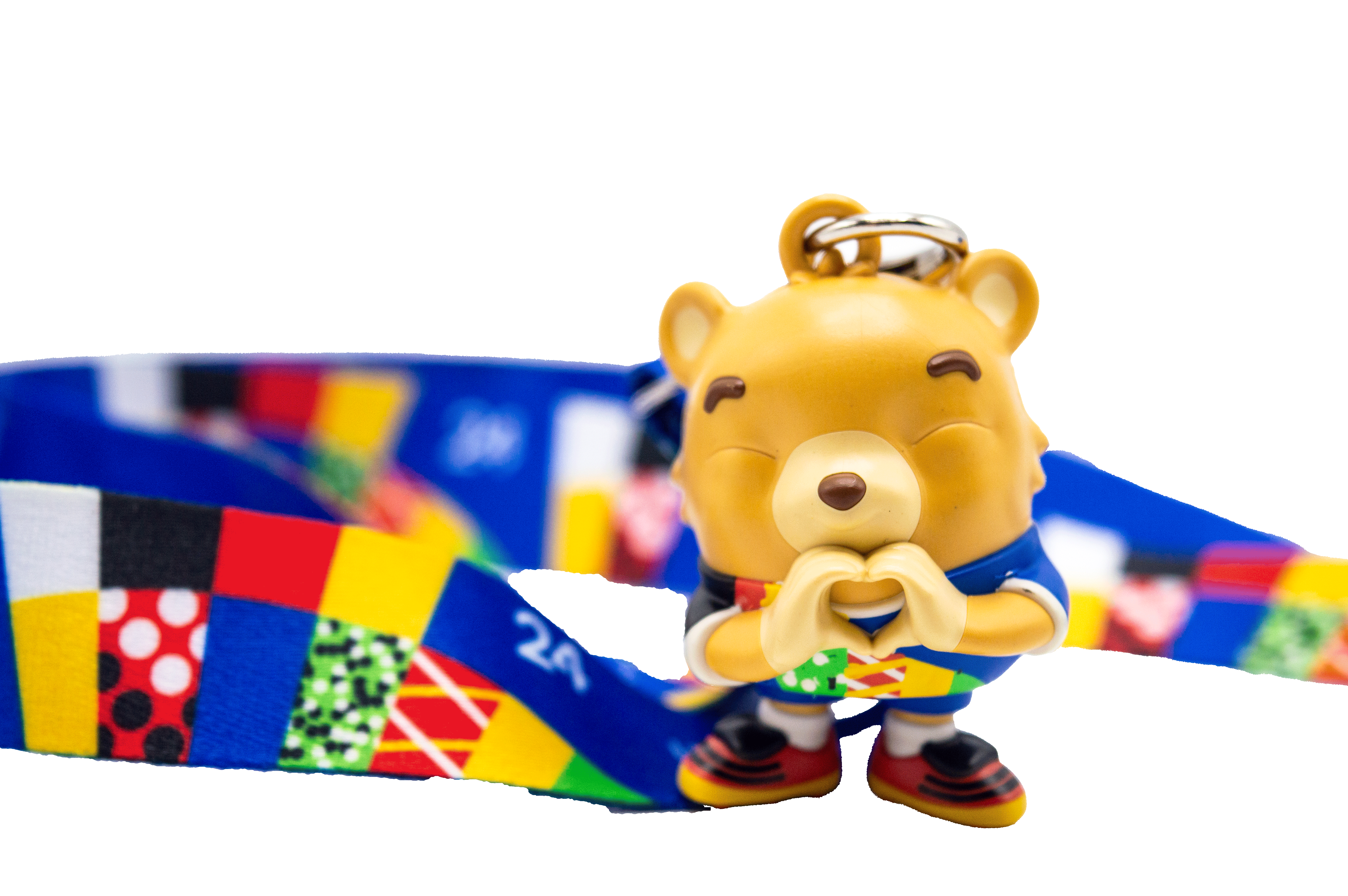 Eine Bärenfigur mit einem Schlüsselband, die eine Herzgeste macht.