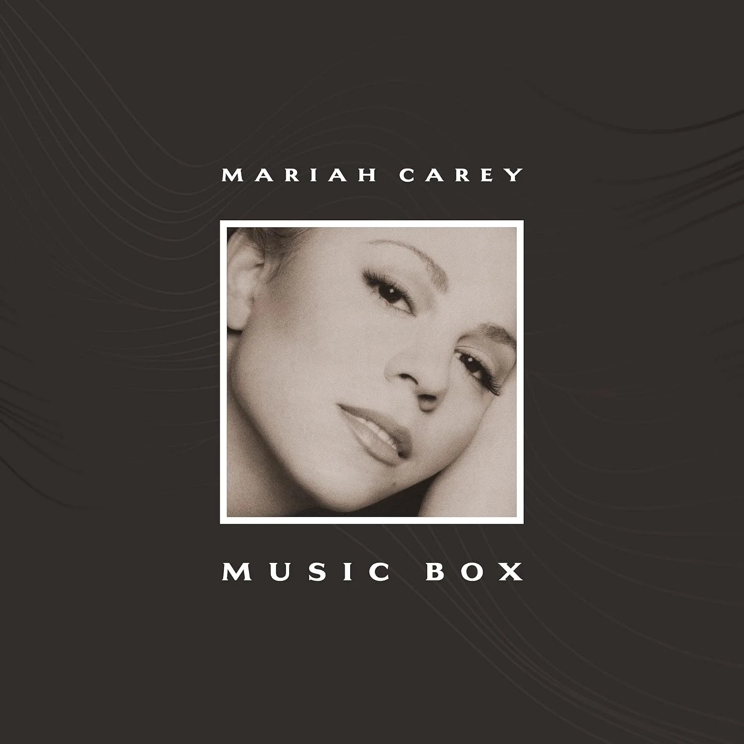 Pochette d'album : Mariah Carey, image sépia, cadre blanc avec texte 'Music Box' sur fond sombre.