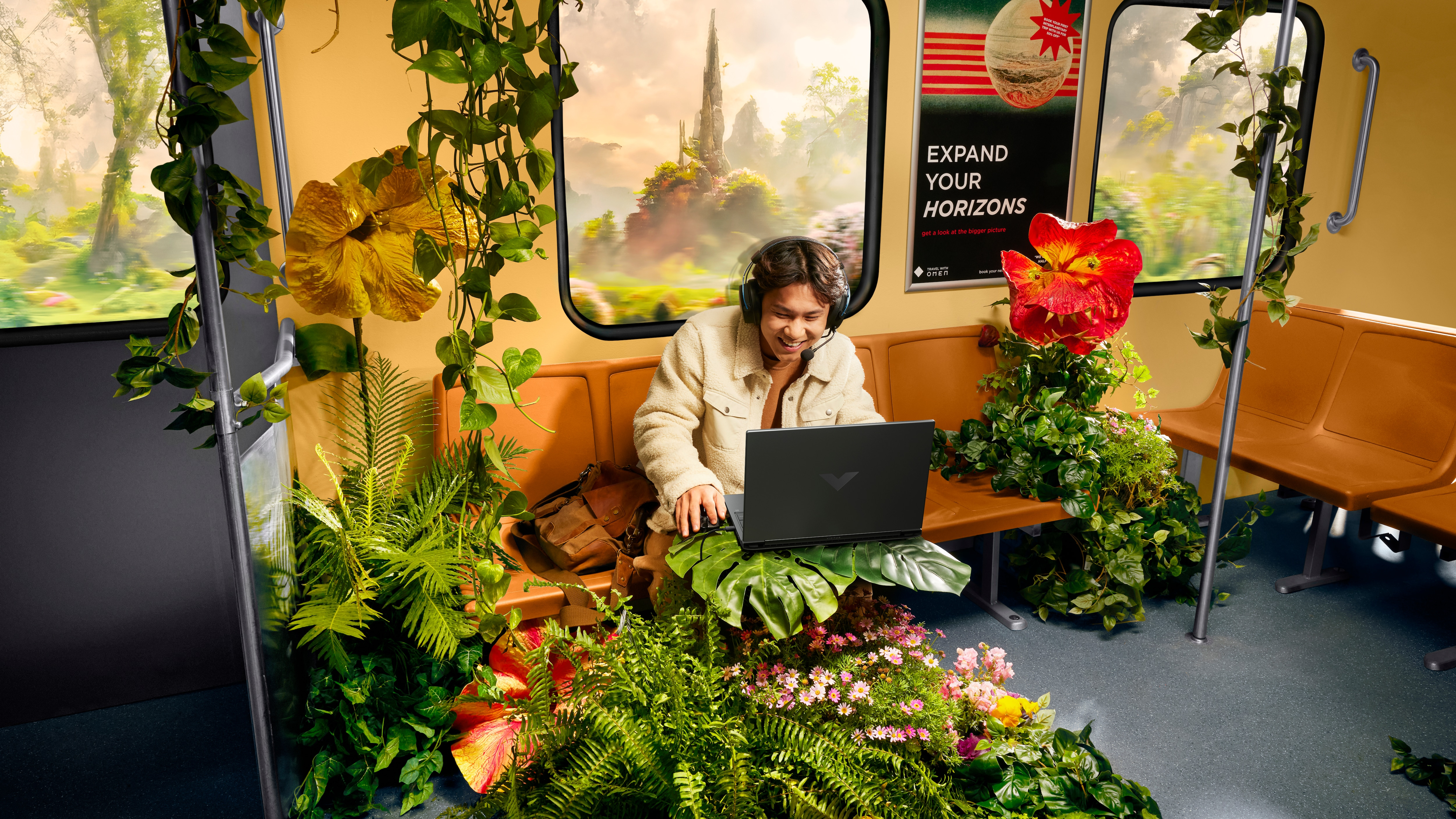 Eine Person benutzt einen Laptop in einem Zug. Der Zug ist mit Pflanzen und Blumen dekoriert.