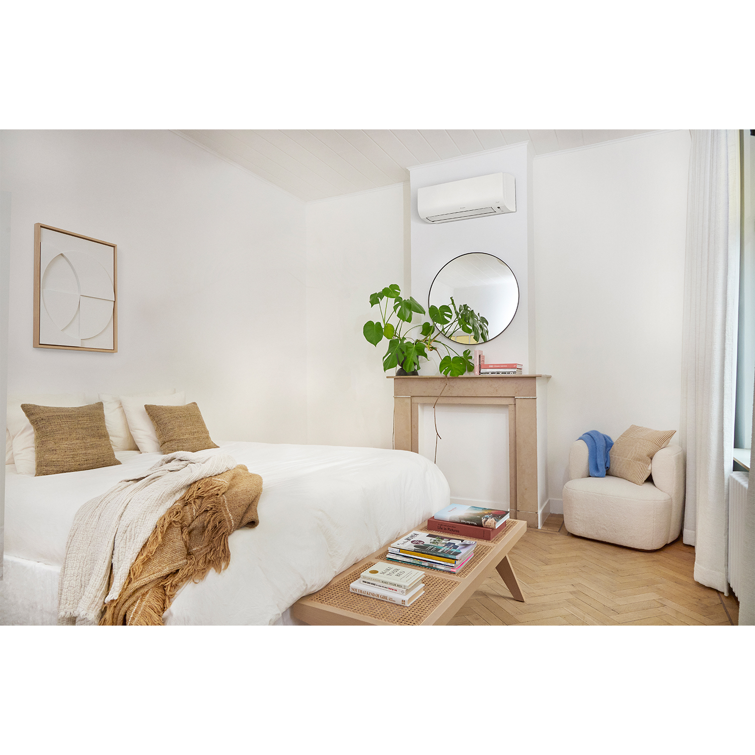 Camera da letto con letto bianco e design moderno. Specchio, arte e libri sulla panca. Pulita e luminosa.