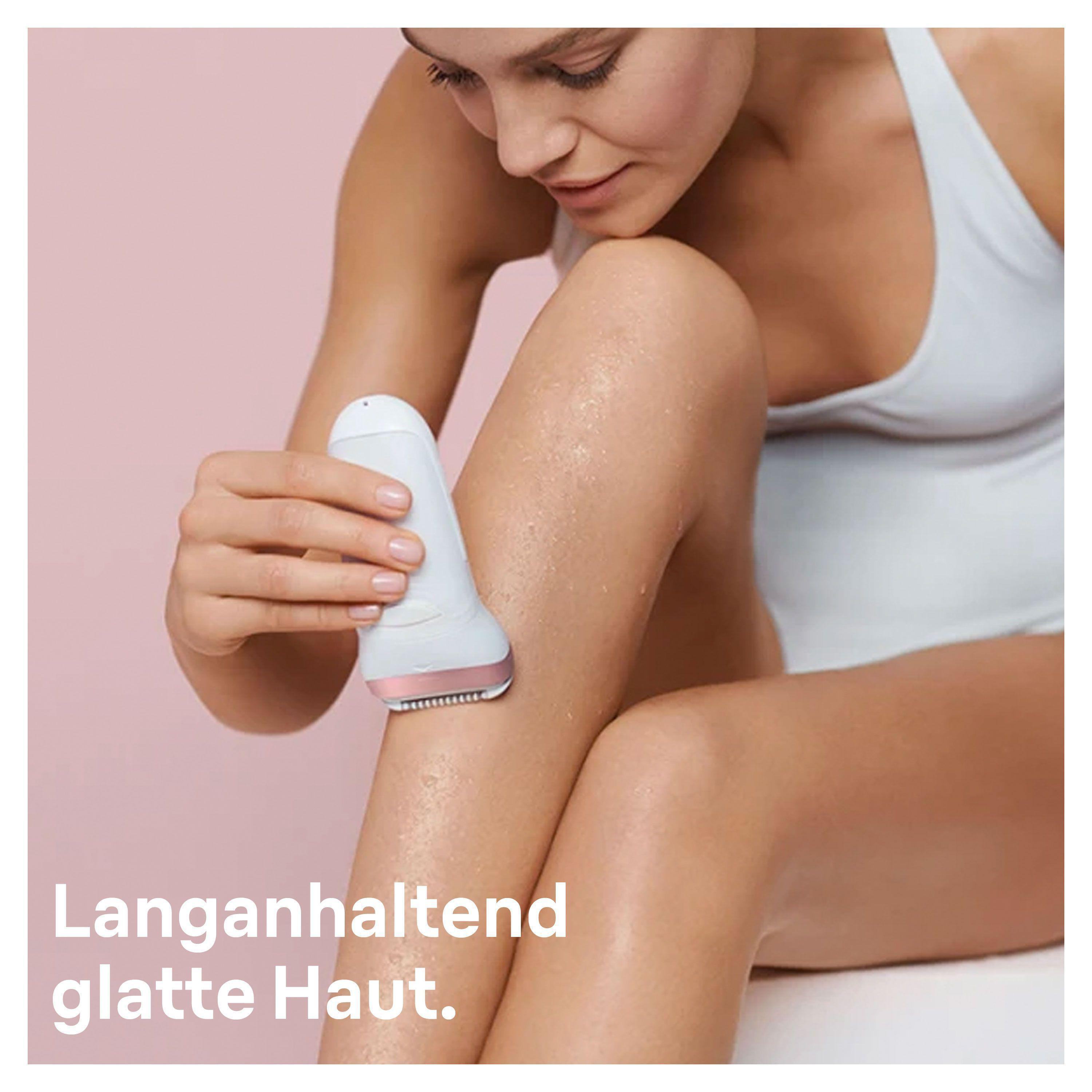 Frau rasiert Bein mit weißem Elektrorasierer, rosa Hintergrund.