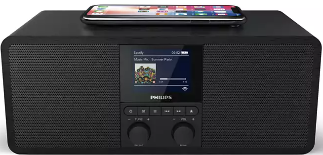 Une radio Philips noire avec un écran affichant Spotify et un téléphone dessus. Boutons sous l'écran.