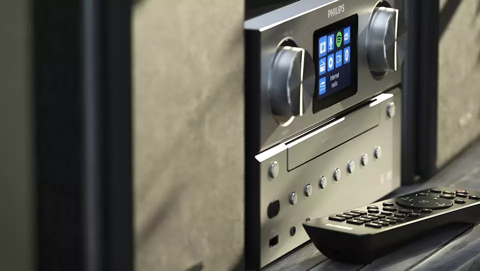 Un impianto stereo argento e nero con display e telecomando.