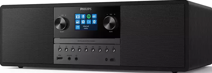 Un sistema audio Philips nero. Ha uno schermo, pulsanti e manopole. Ha una porta USB e un jack per cuffie. Si trova su una superficie bianca.