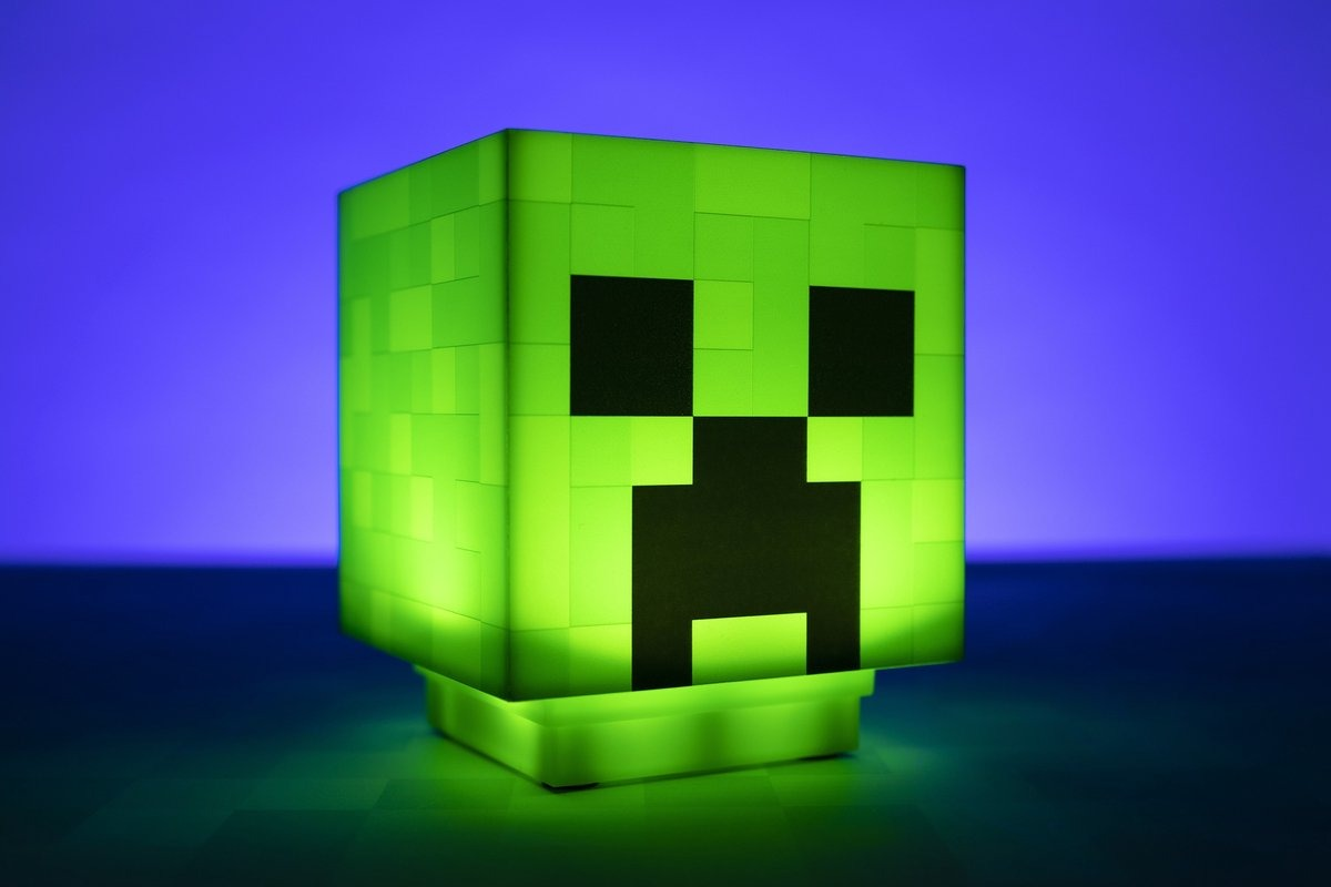 Green Minecraft Creeper lamp glowing on a dark surface.