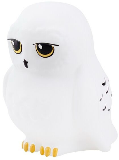 Une figurine de hibou blanc avec de grands yeux jaunes et des pieds dorés, en position assise.