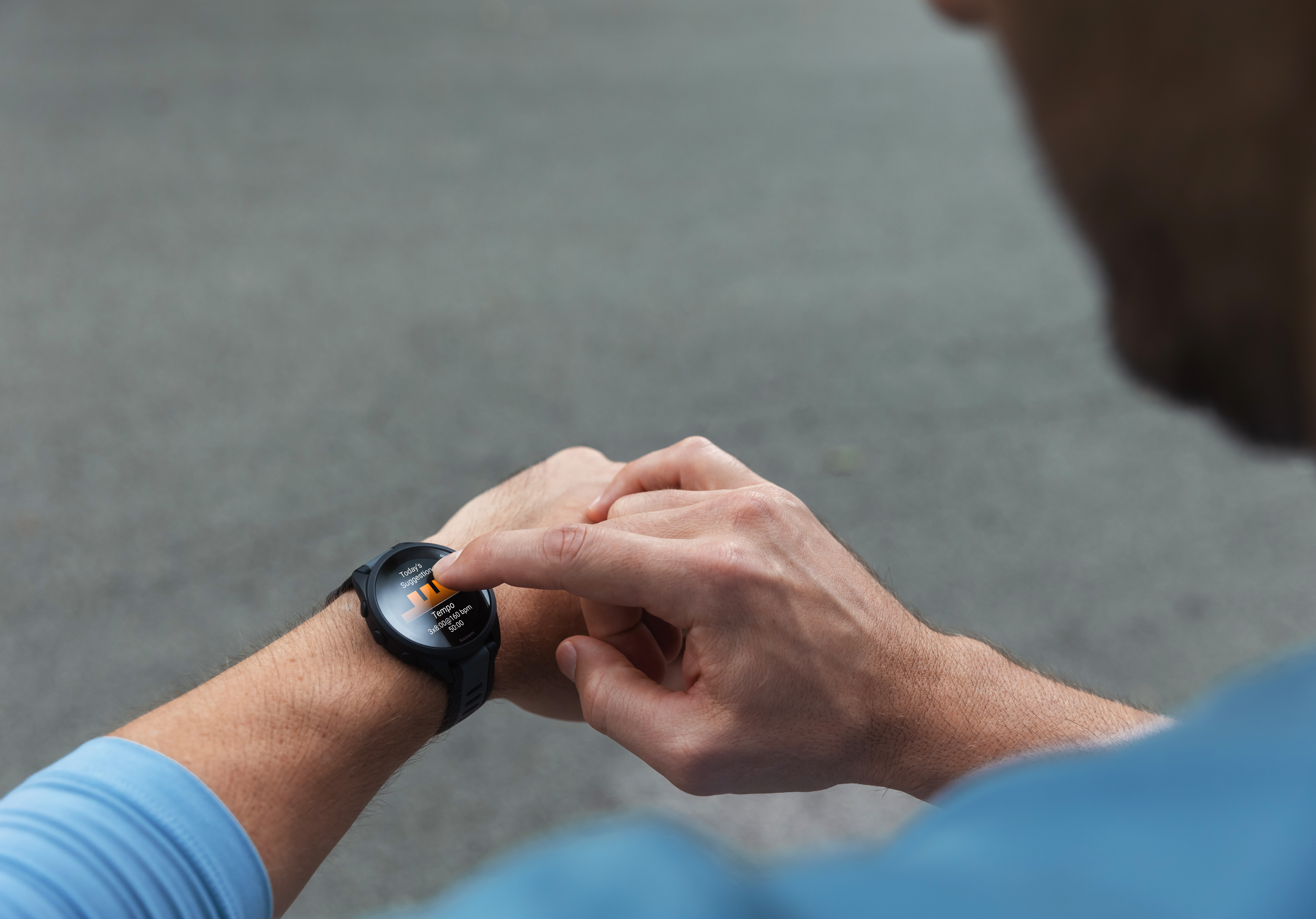 Person, die eine Smartwatch trägt und mit dem Zeigefinger auf den Bildschirm tippt.