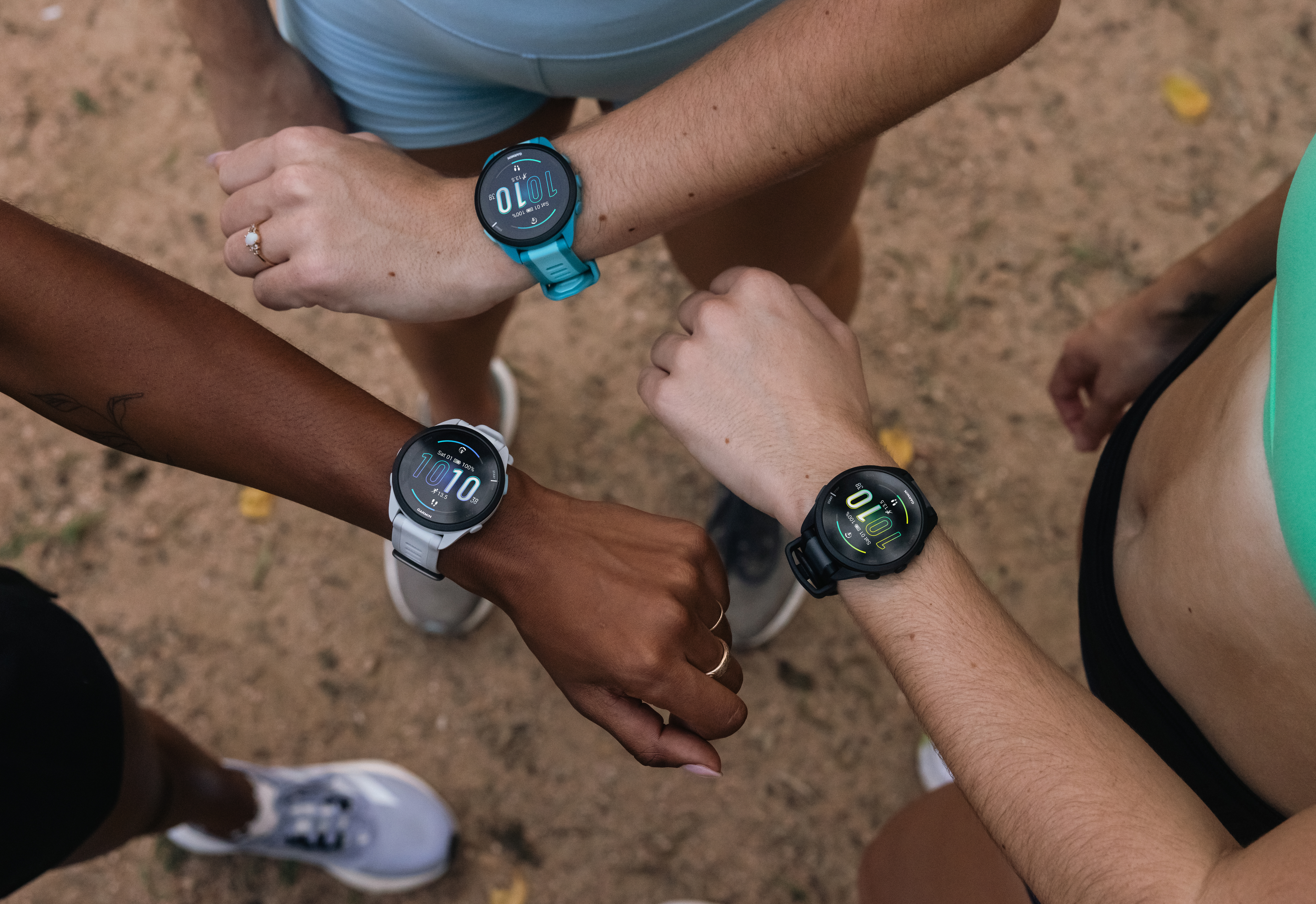 Drei Personen mit Smartwatches am Handgelenk, die Zeit und Statistiken anzeigen.