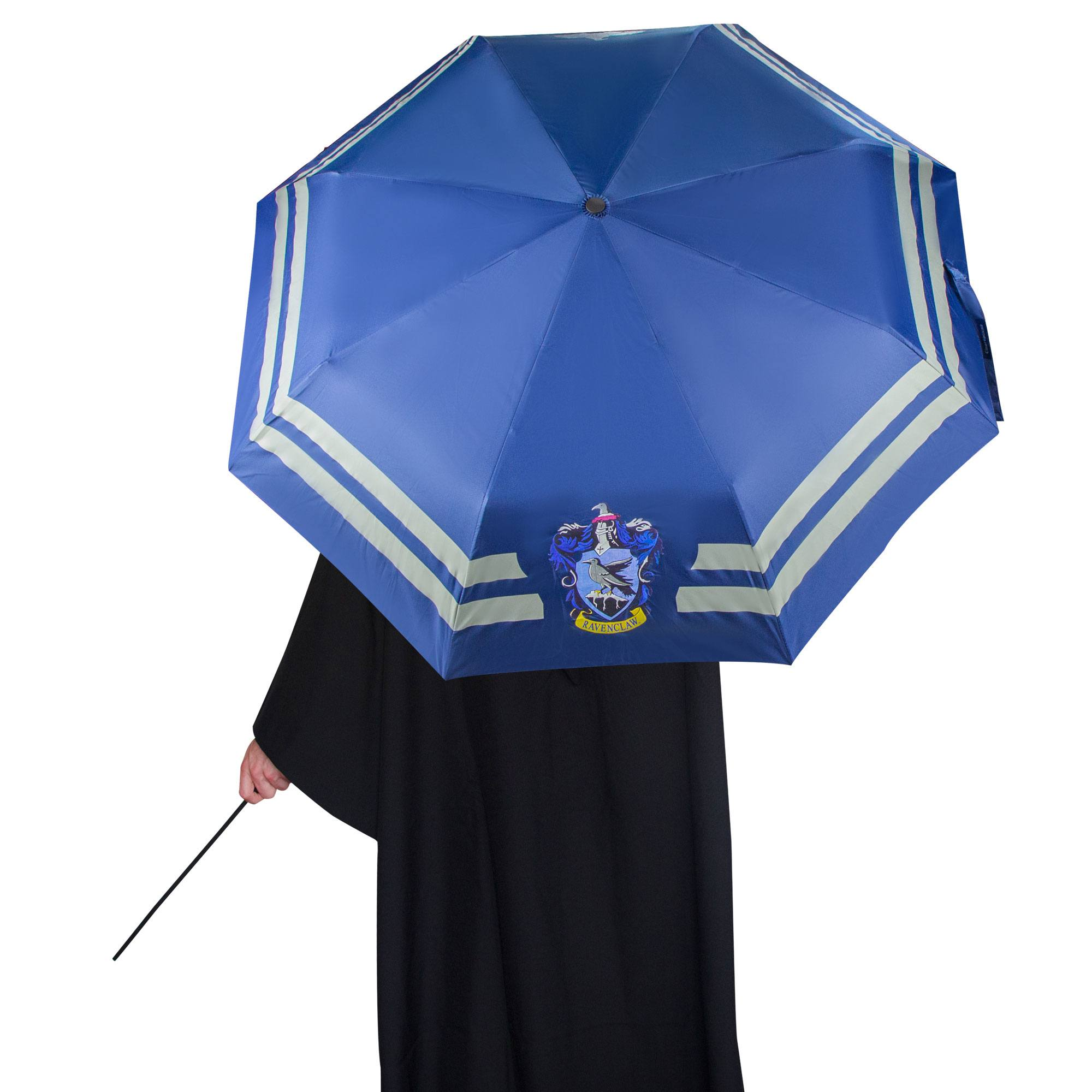 Eine Person hält einen blauen, offenen Ravenclaw-Regenschirm. Die Person trägt einen schwarzen Umhang.