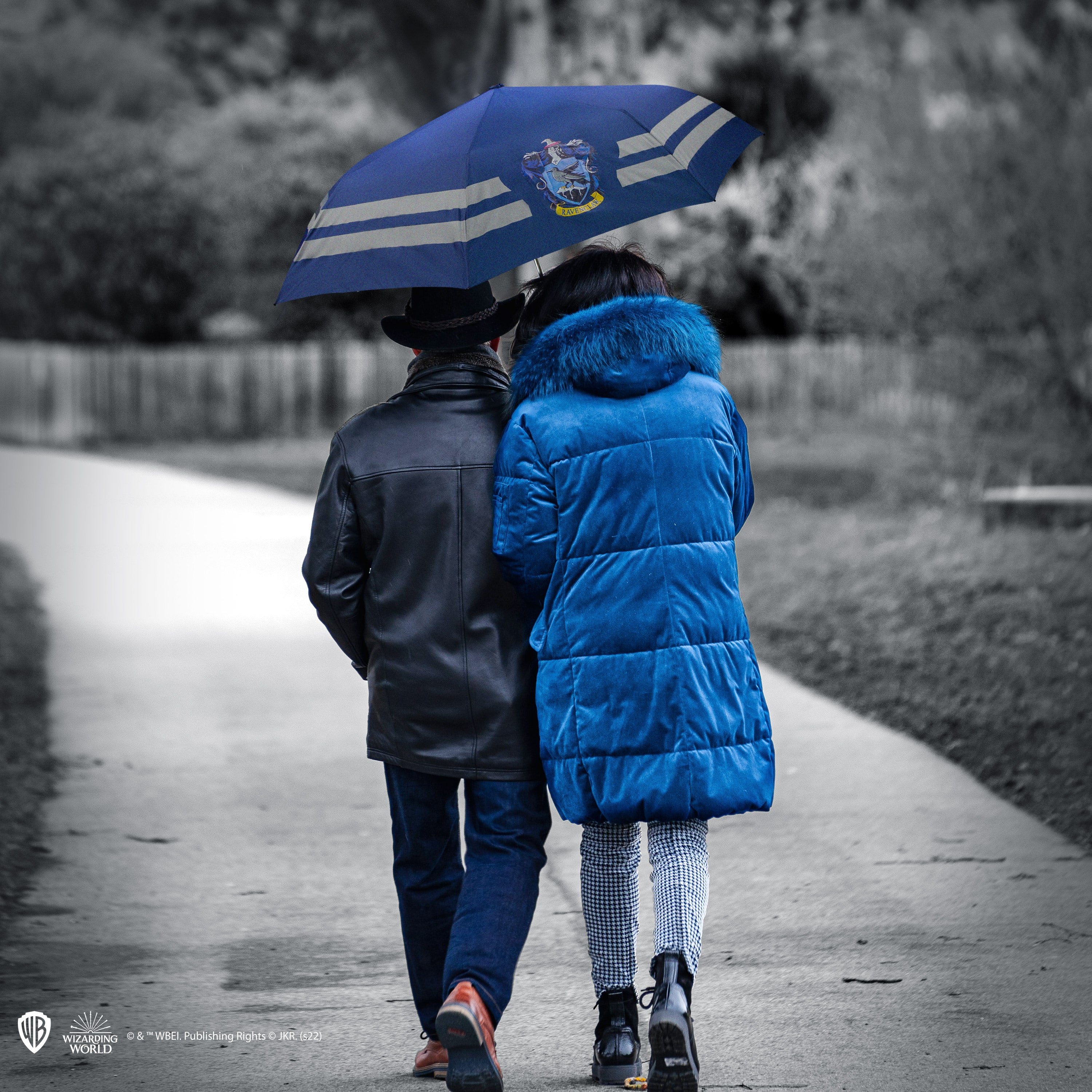 Paar geht unter einem Regenschirm, Graustufenhintergrund.