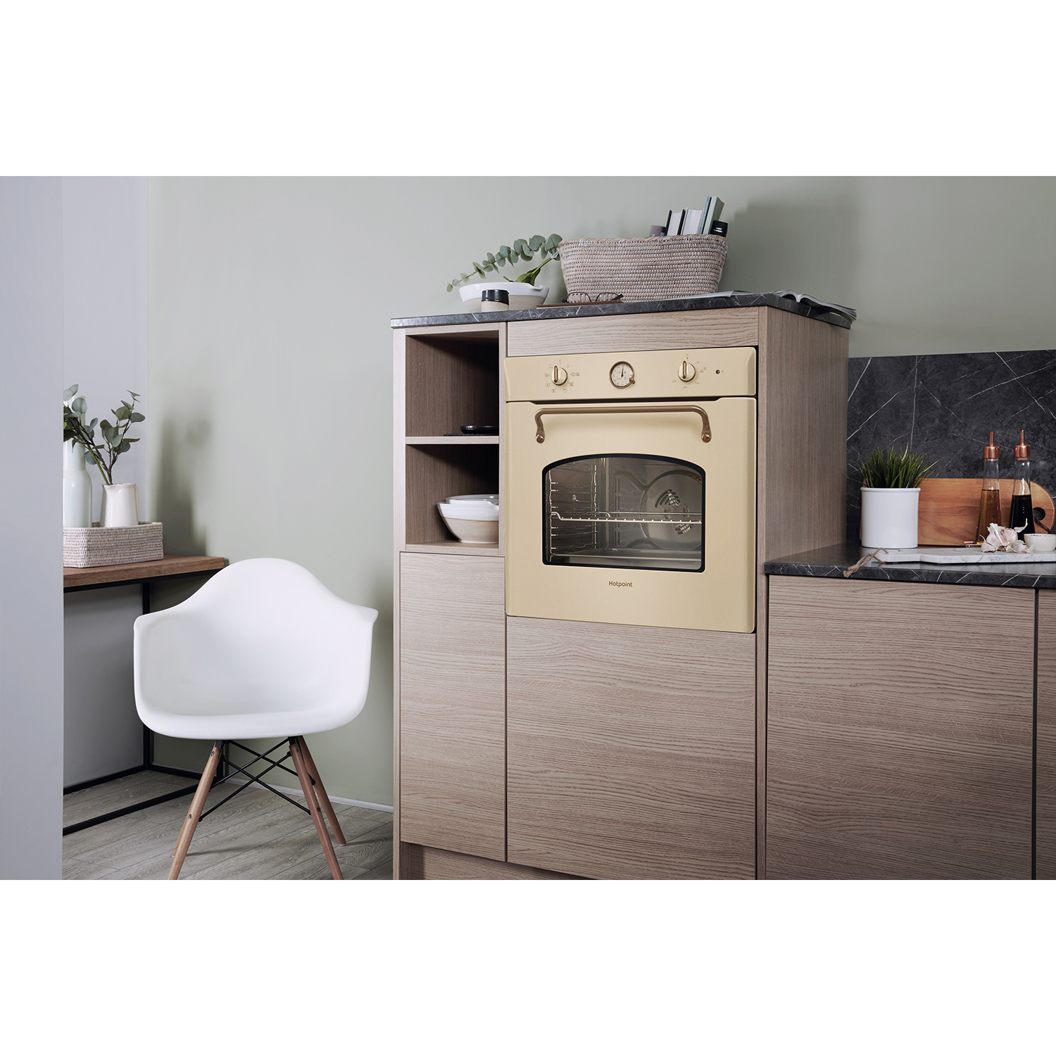 Cucina con forno beige. Sono visibili anche una sedia, utensili e decorazioni.
