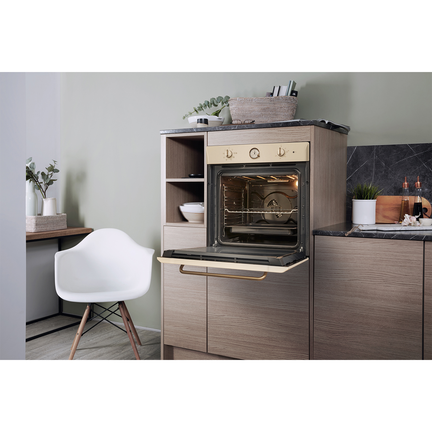 Un forno aperto integrato in mobili di legno con una sedia bianca davanti.