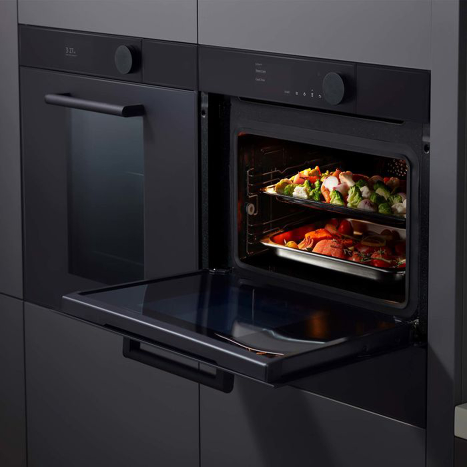 Forno a incasso con porta aperta. I vassoi con il cibo sono visibili all'interno del forno.