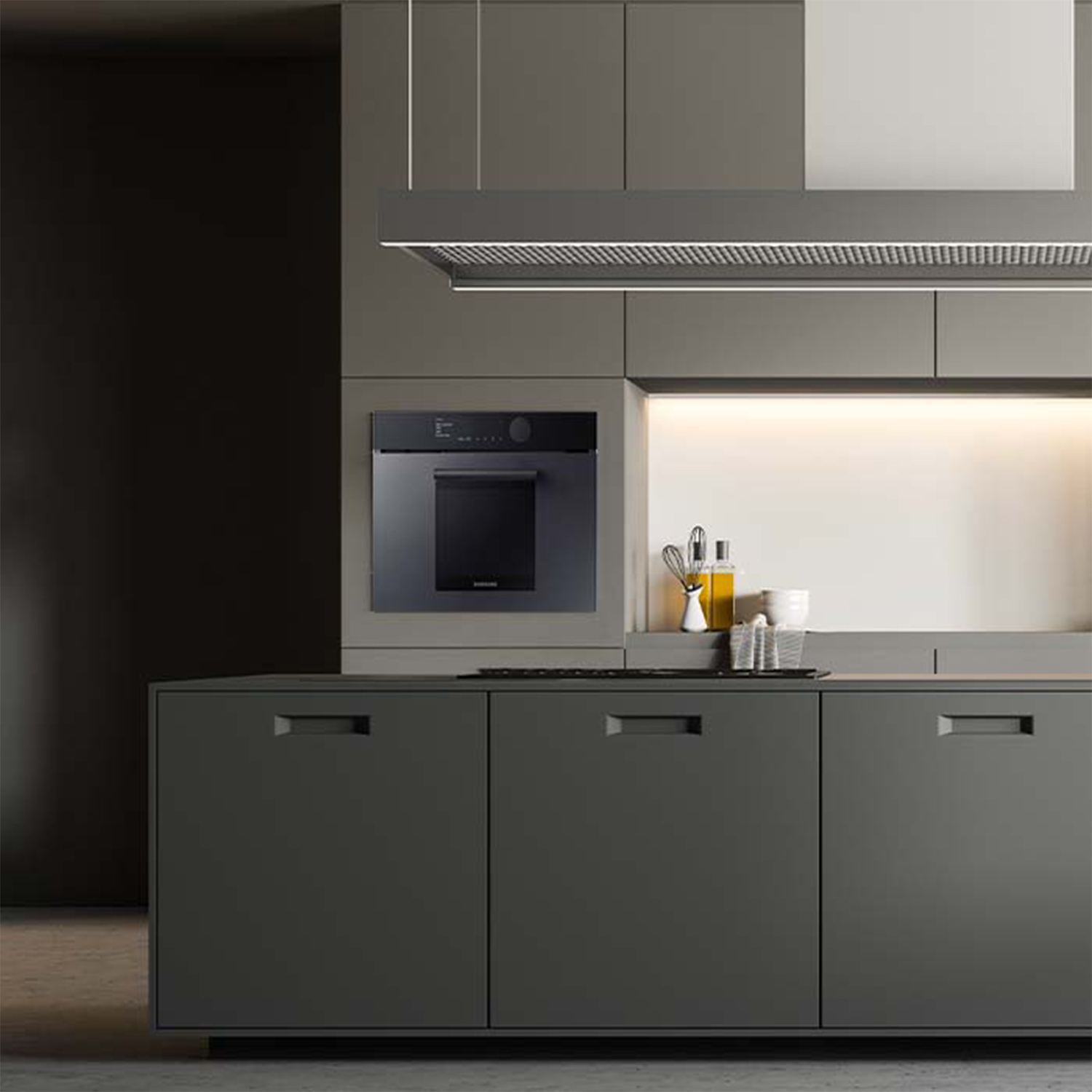 Una cucina moderna con mobili e elettrodomestici grigi. Un forno è nel muro.