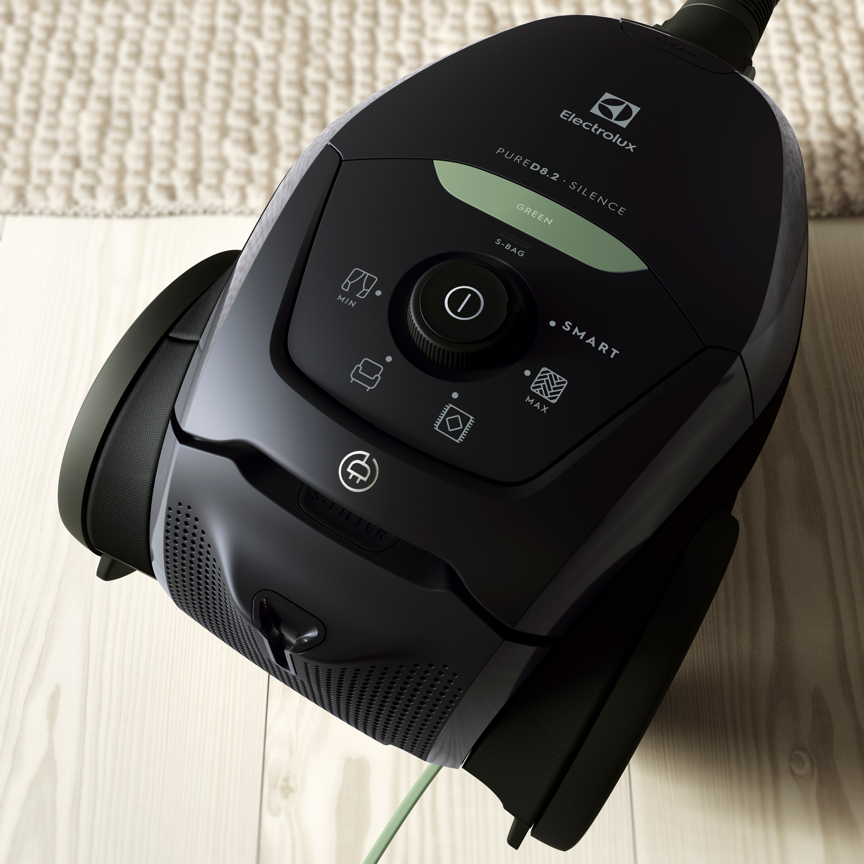 Aspirateur Electrolux noir sur plancher en bois, vue de dessus.