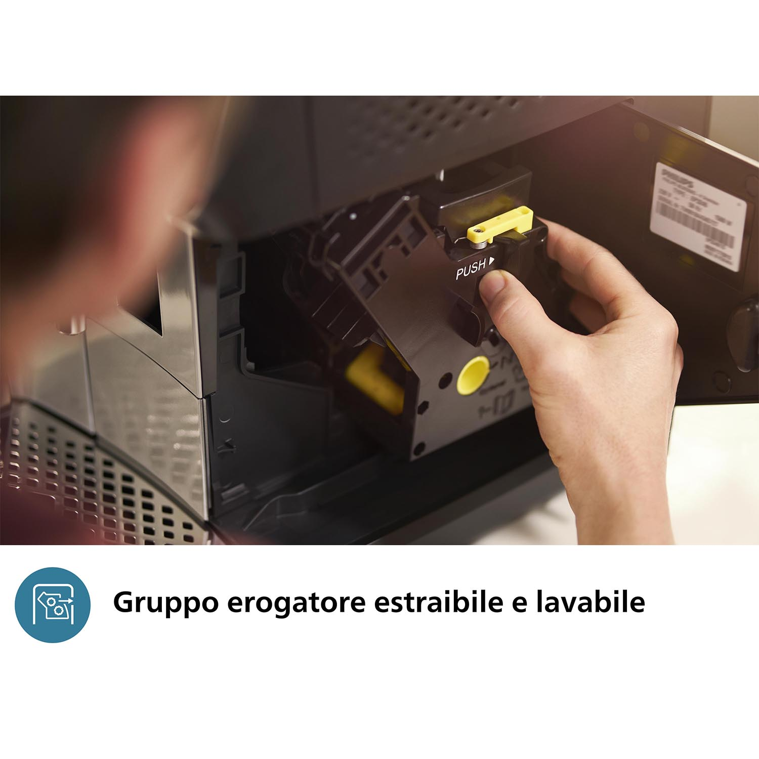 La mano di una persona sta rimuovendo un componente nero e giallo di una macchina da caffè.