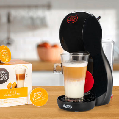 Ekspres do kawy ze szklanką latte macchiato i kapsułkami latte.