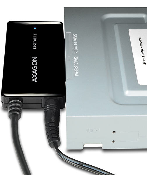 Fekete Axagon FastPort3 adapter DVD-íróhoz csatlakoztatva. Fekete kábel köti össze mindkettőt.