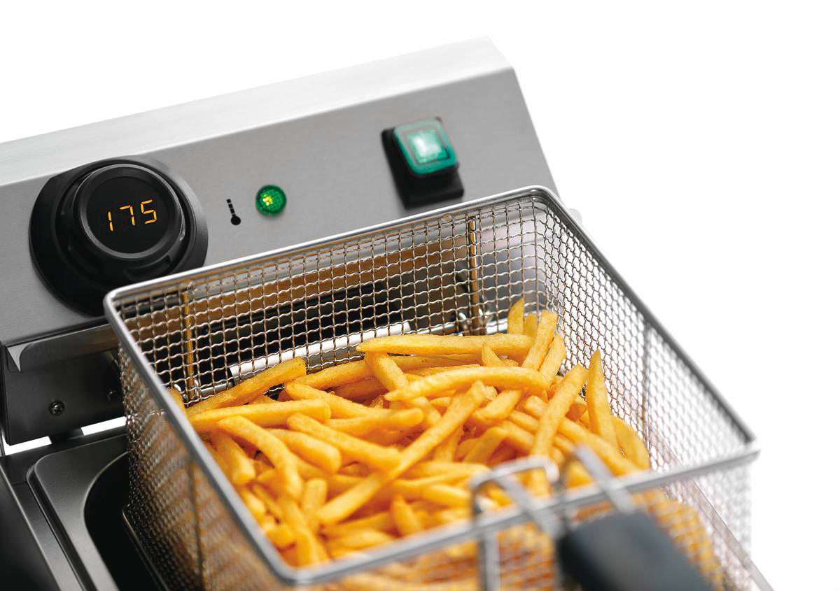 Ein gewerblicher Fritteuse mit einem Korb voller goldener Pommes Frites. Ein Zifferblatt zeigt 175 Grad an. Grüne Lichter zeigen den Betrieb an.