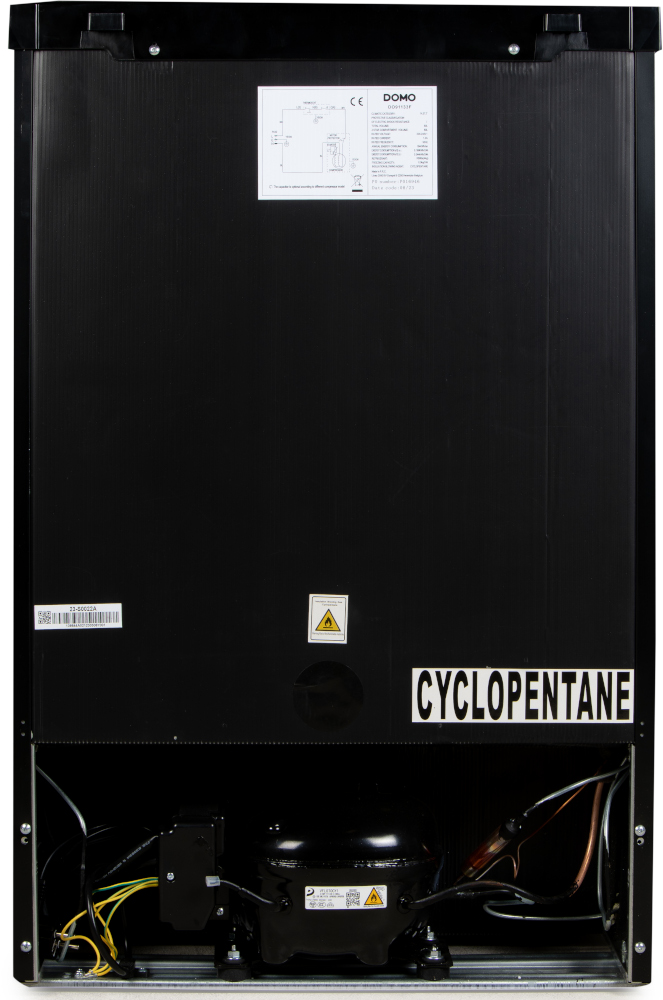 Arrière d'un réfrigérateur noir avec composants, et une étiquette 'CYCLOPENTANE'.