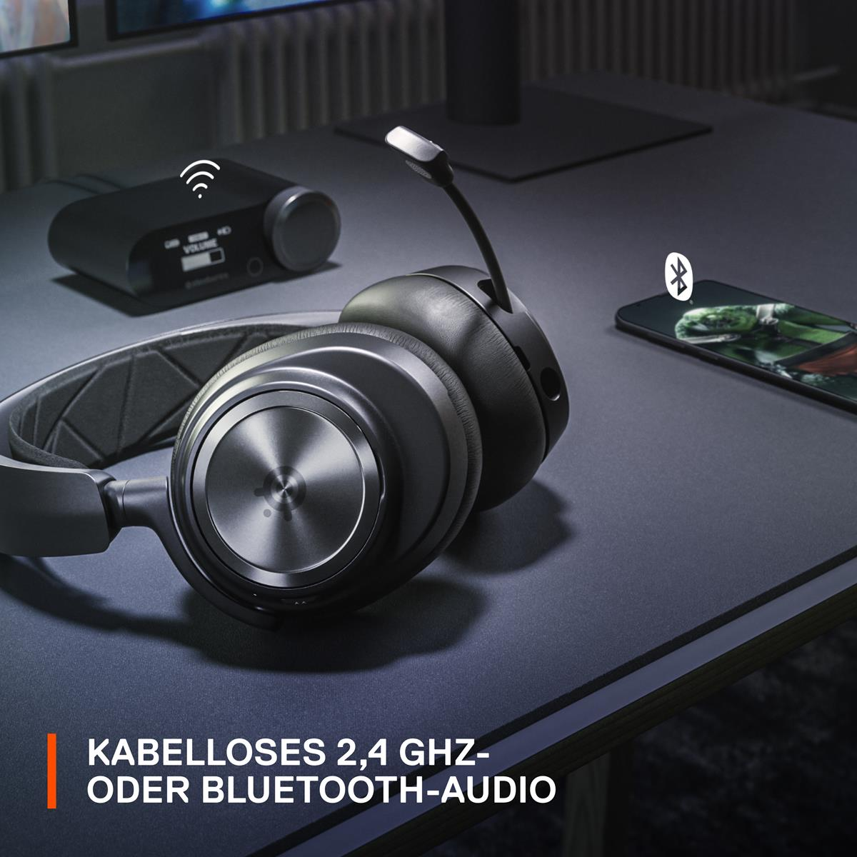 Schwarze kabellose Kopfhörer mit Mikrofon auf dunklem Schreibtisch, mit Telefon.